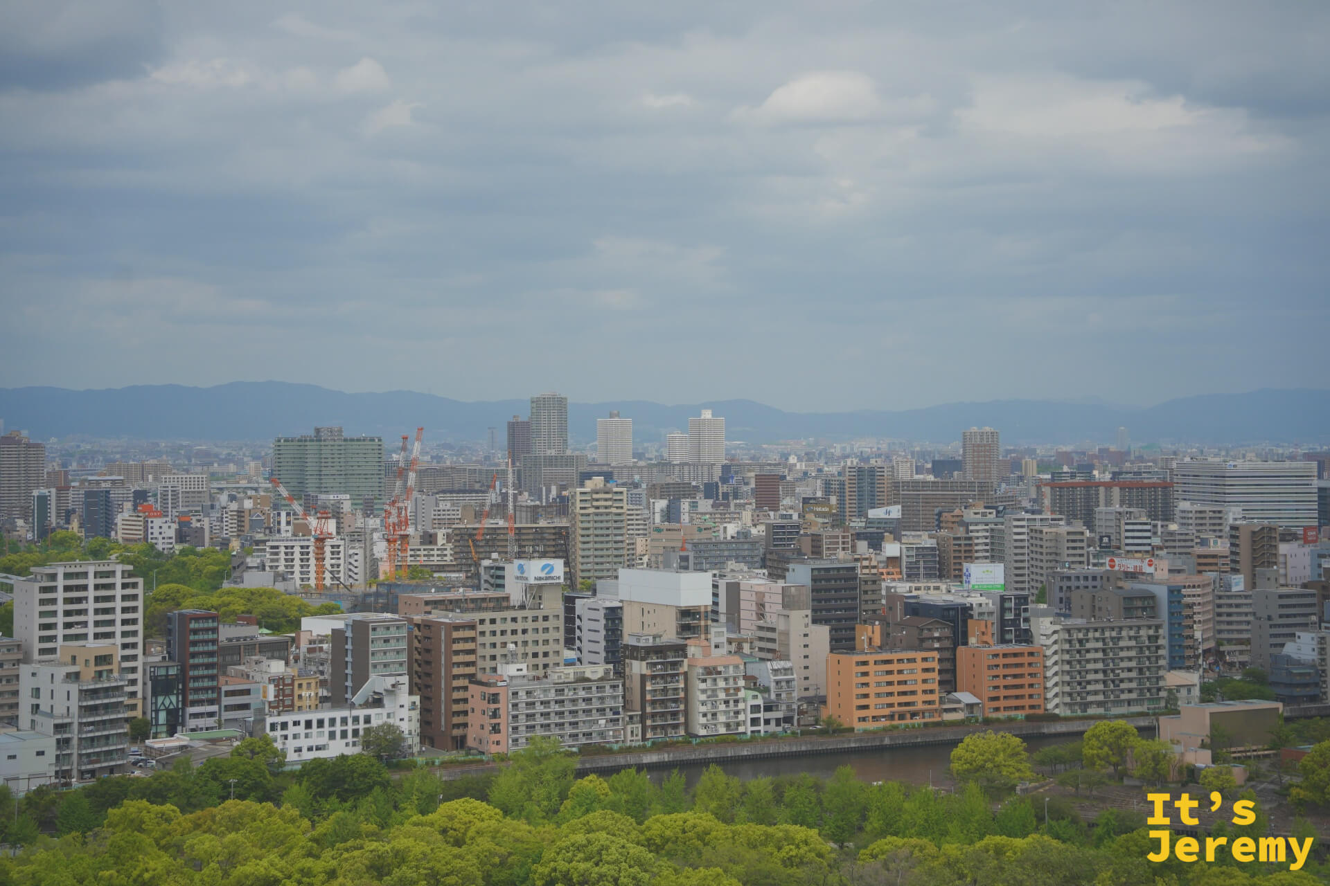 從頂層展望台俯瞰大阪市區全景，建築群延伸至遠方山脈