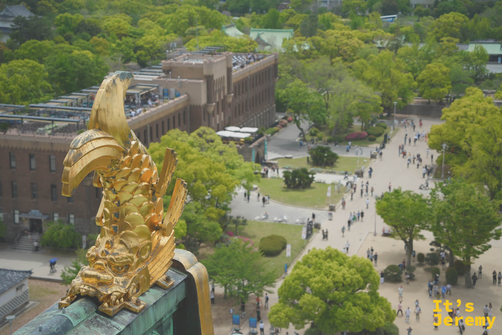 另一側金鯱特寫，遠方是大阪城公園廣場與博物館建築