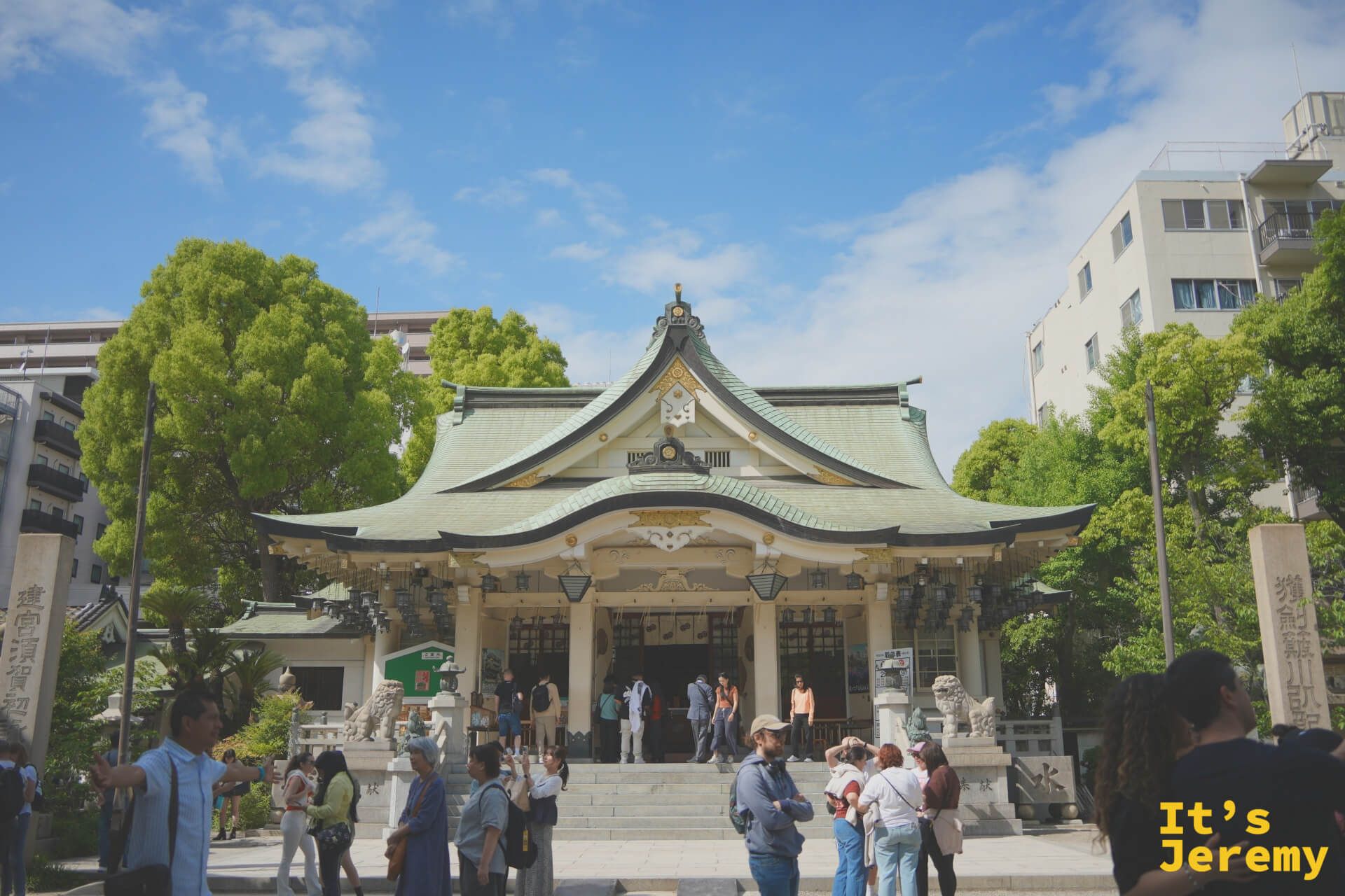 難波八阪神社拜殿正面全景，藍天白牆翠綠屋頂