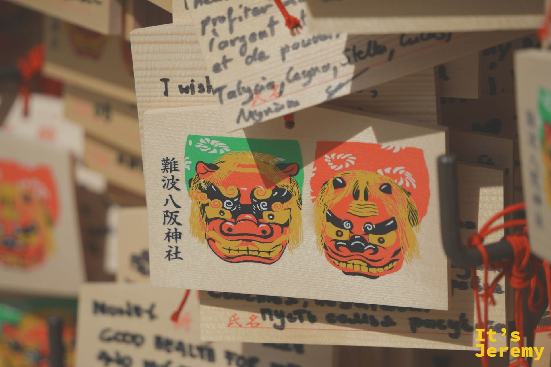 繪馬特寫，難波八阪神社獅子圖案清晰可見，旁邊有外文許願文字
