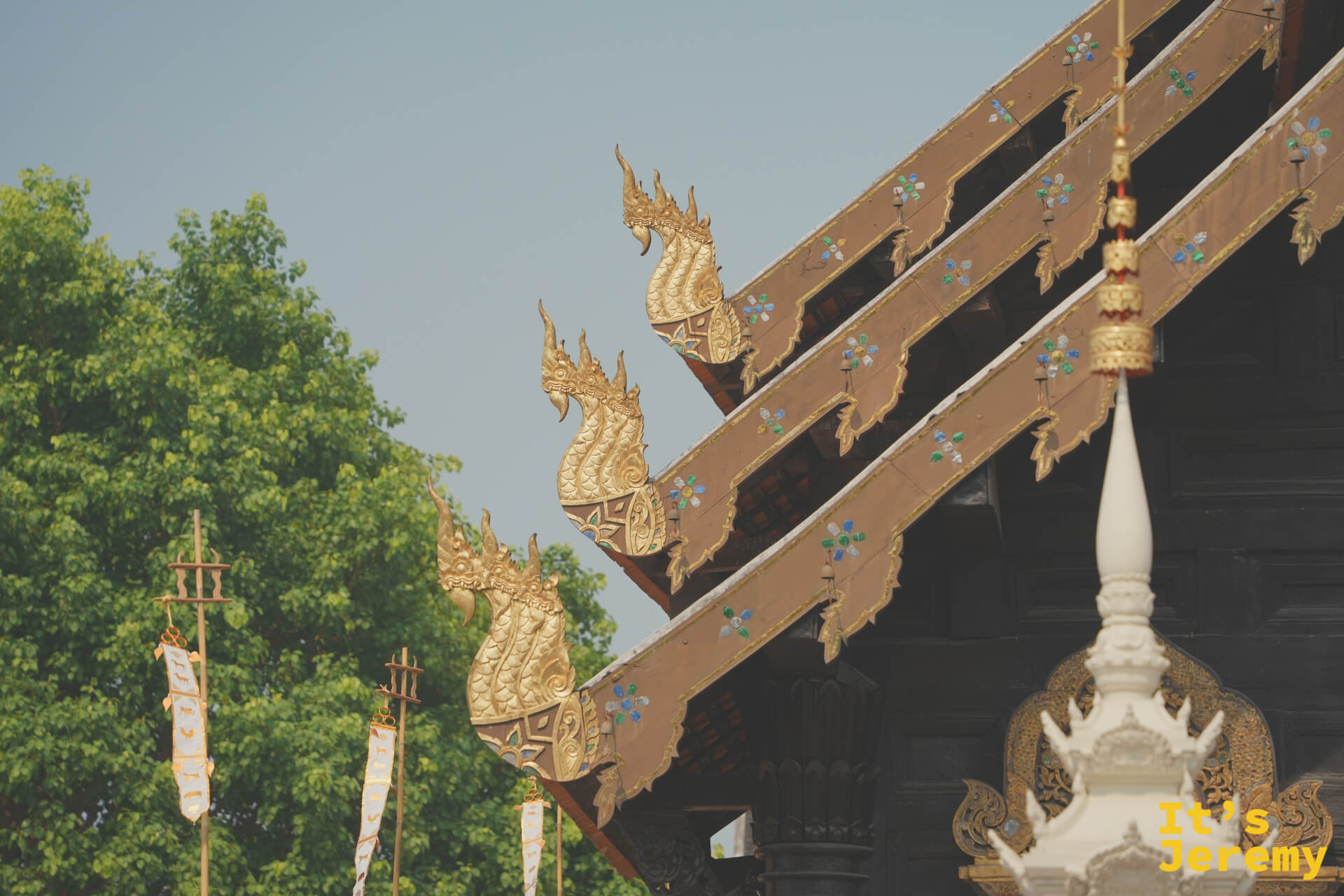 盼道寺多層屋簷末端的金色 Hamsa 神鳥裝飾，白色旗幡飄揚