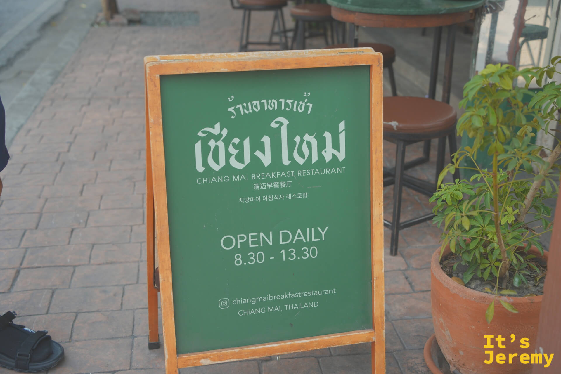 店外深綠色 A-frame 立牌,寫著 OPEN DAILY 8:30-13:30 與 IG 帳號