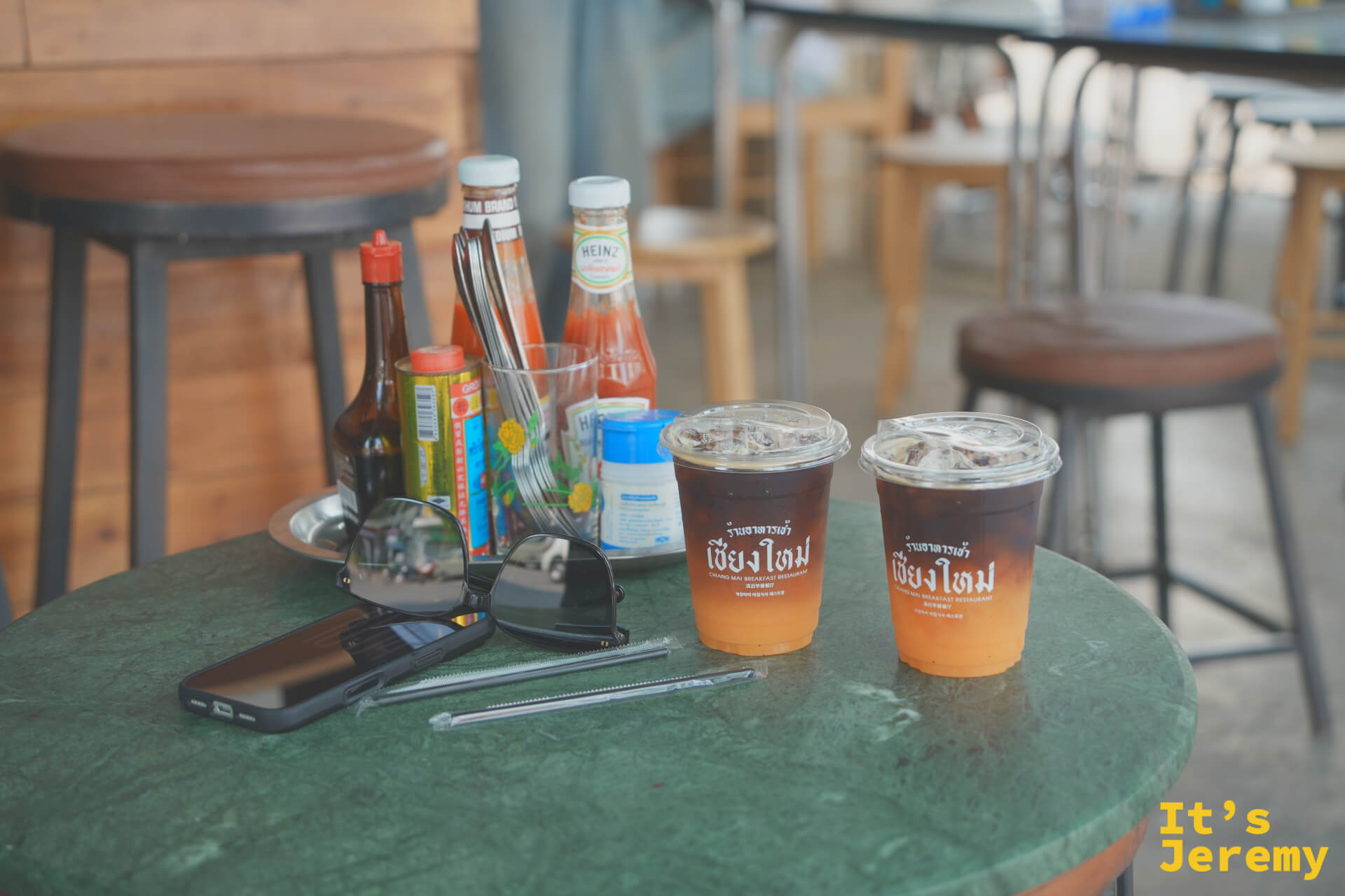 桌上兩杯 Orange Americano,旁邊放著太陽眼鏡和手機