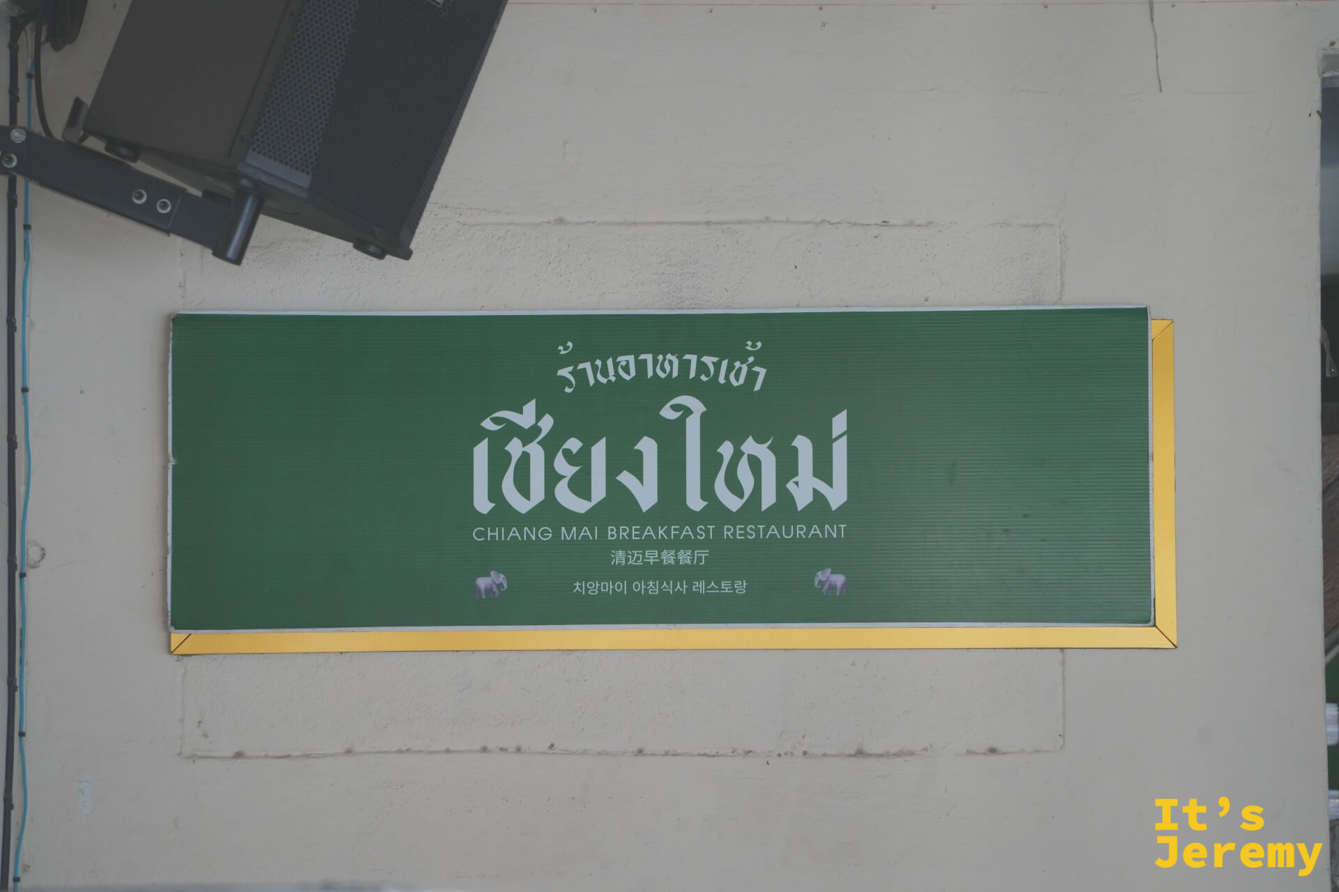 牆面大型招牌,白字標示多語言店名
