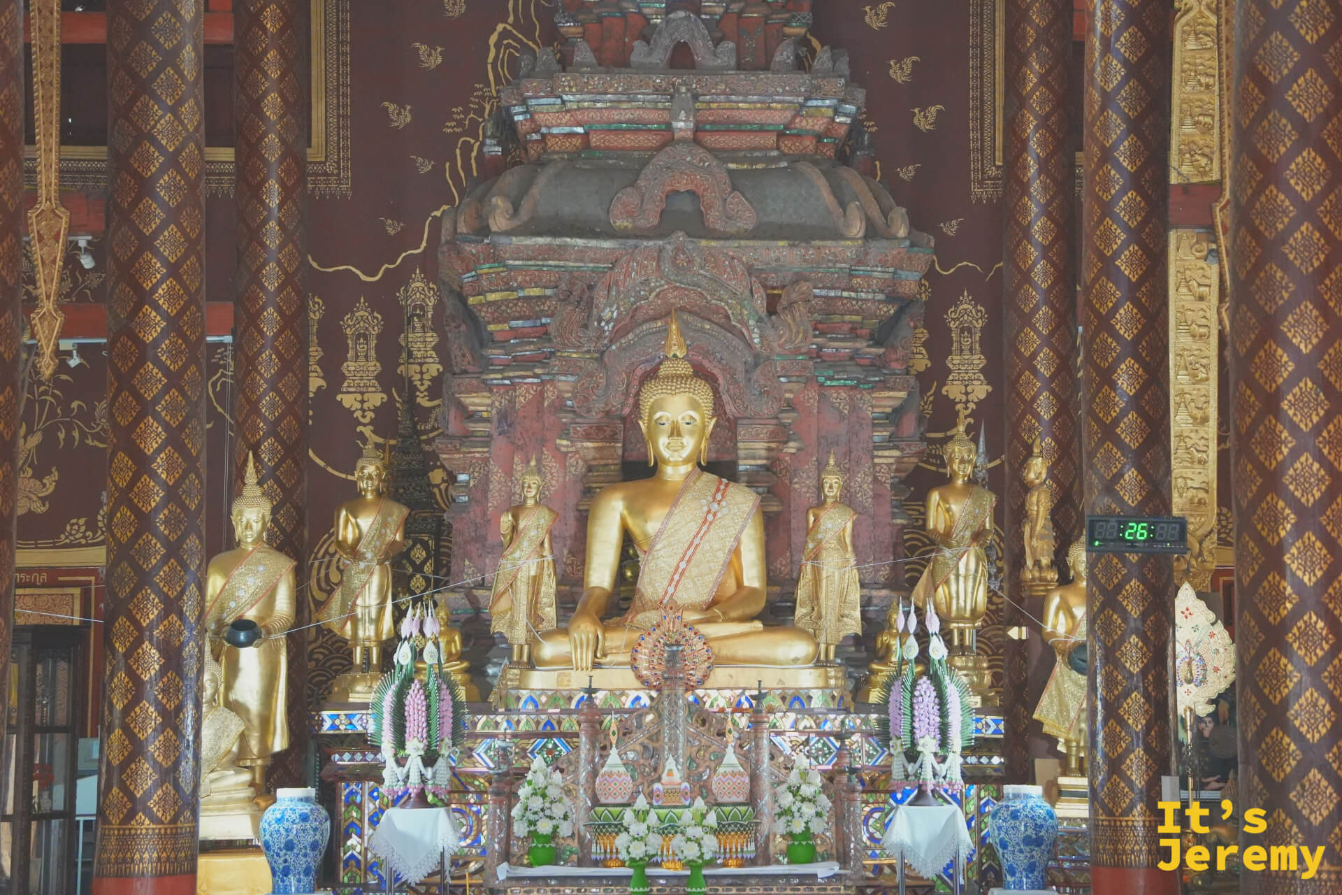 主殿正面全景,金佛端坐高台,兩側侍立小佛像,後方背景壁畫宏大