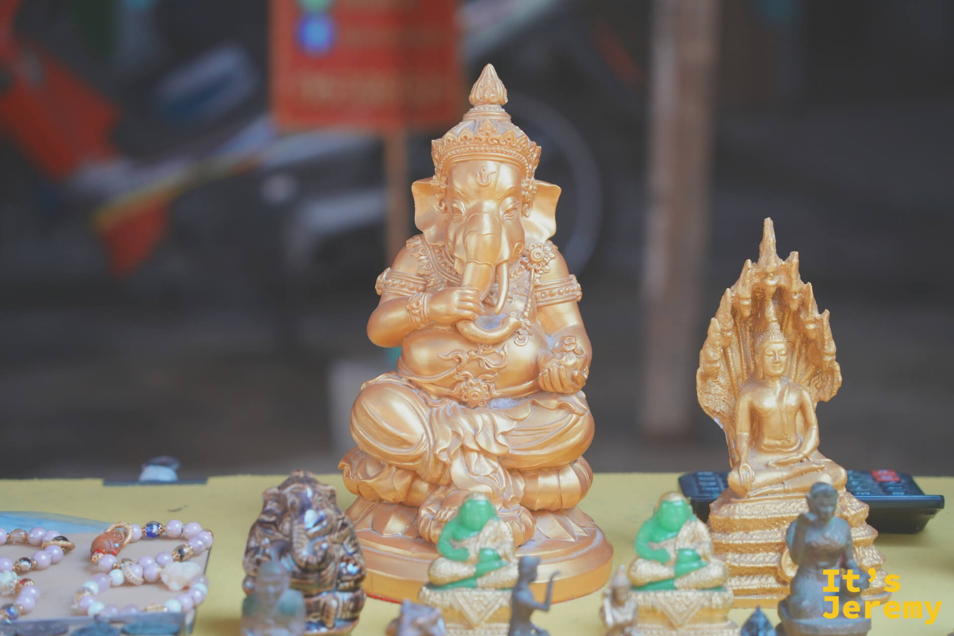 攤位上的象頭神（Ganesh）塑像與各式佛牌，陳列隨性，充滿市集氣息