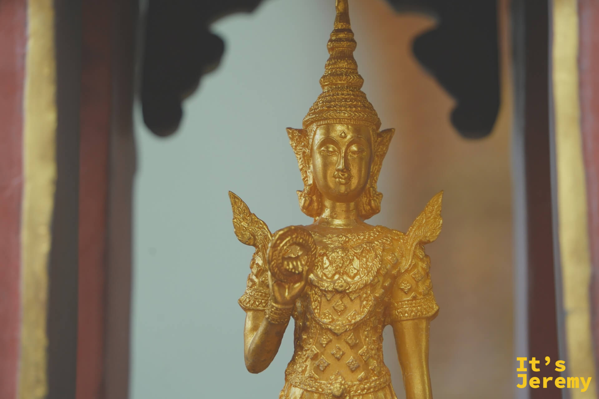金色女性天神立像，雙手持法器，全身金色飾紋細密，神情優雅