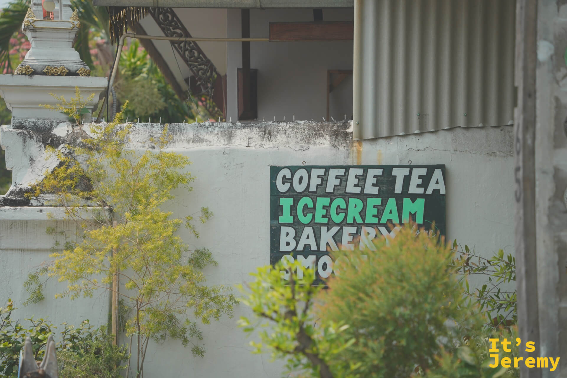 帕辛寺附近廟牆上的手繪招牌,寫著 Coffee、Tea、Ice Cream 和 Bakery,白色佛塔就在旁邊