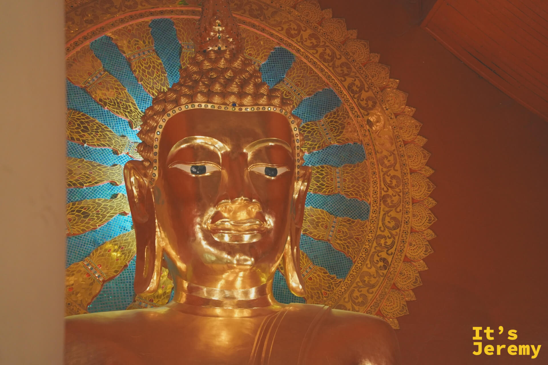 主殿大佛臉部特寫,金色佛面,藍色馬賽克圓形背光,神情沉靜