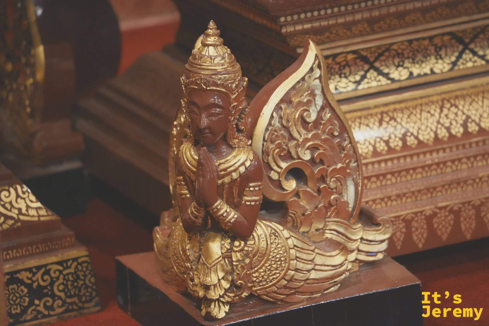 木雕天神合十小像,依偎在牆面凹龕中