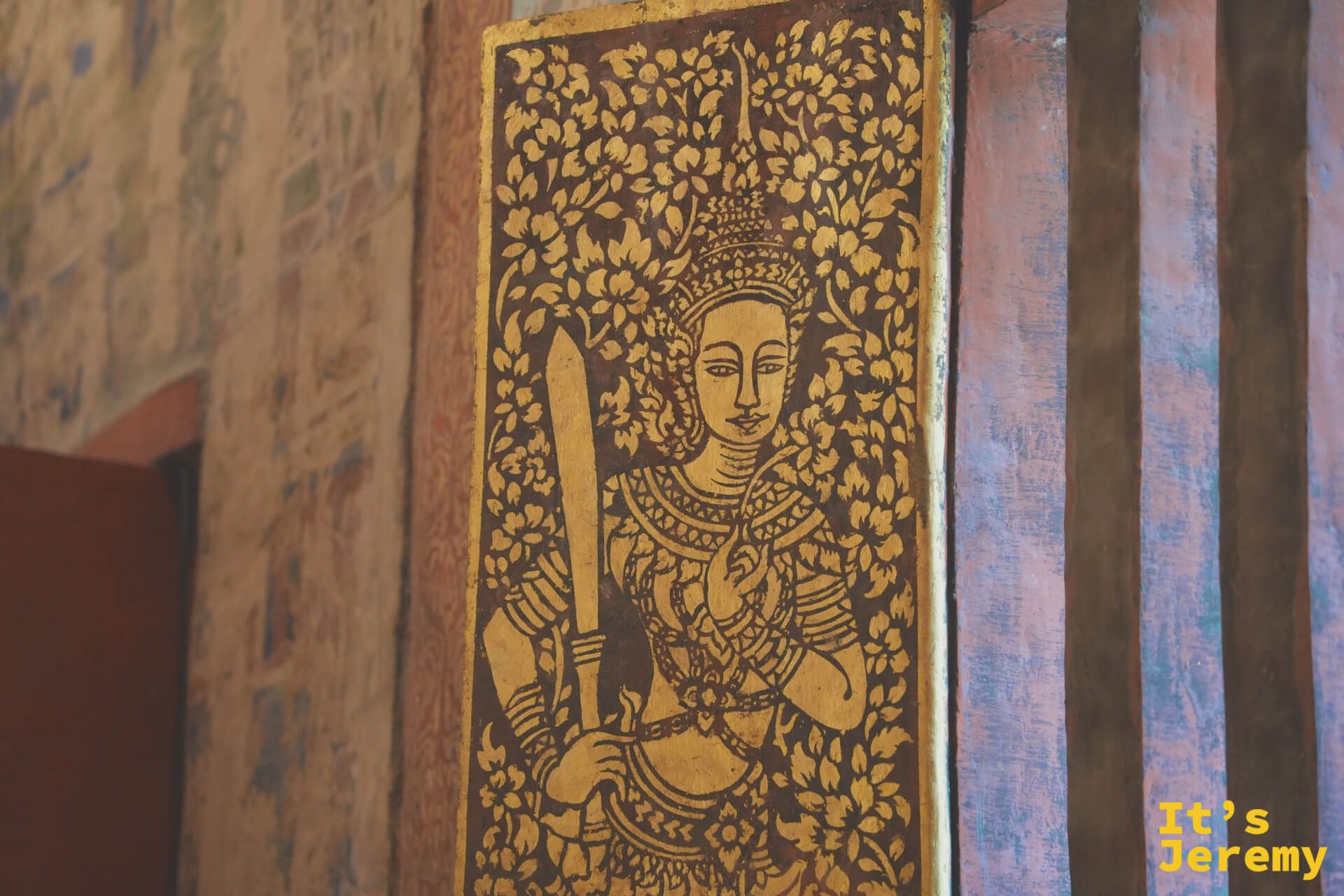柱面木雕彩繪板,金色天神(武士)手持長劍,黑棕底金色花葉紋為背景