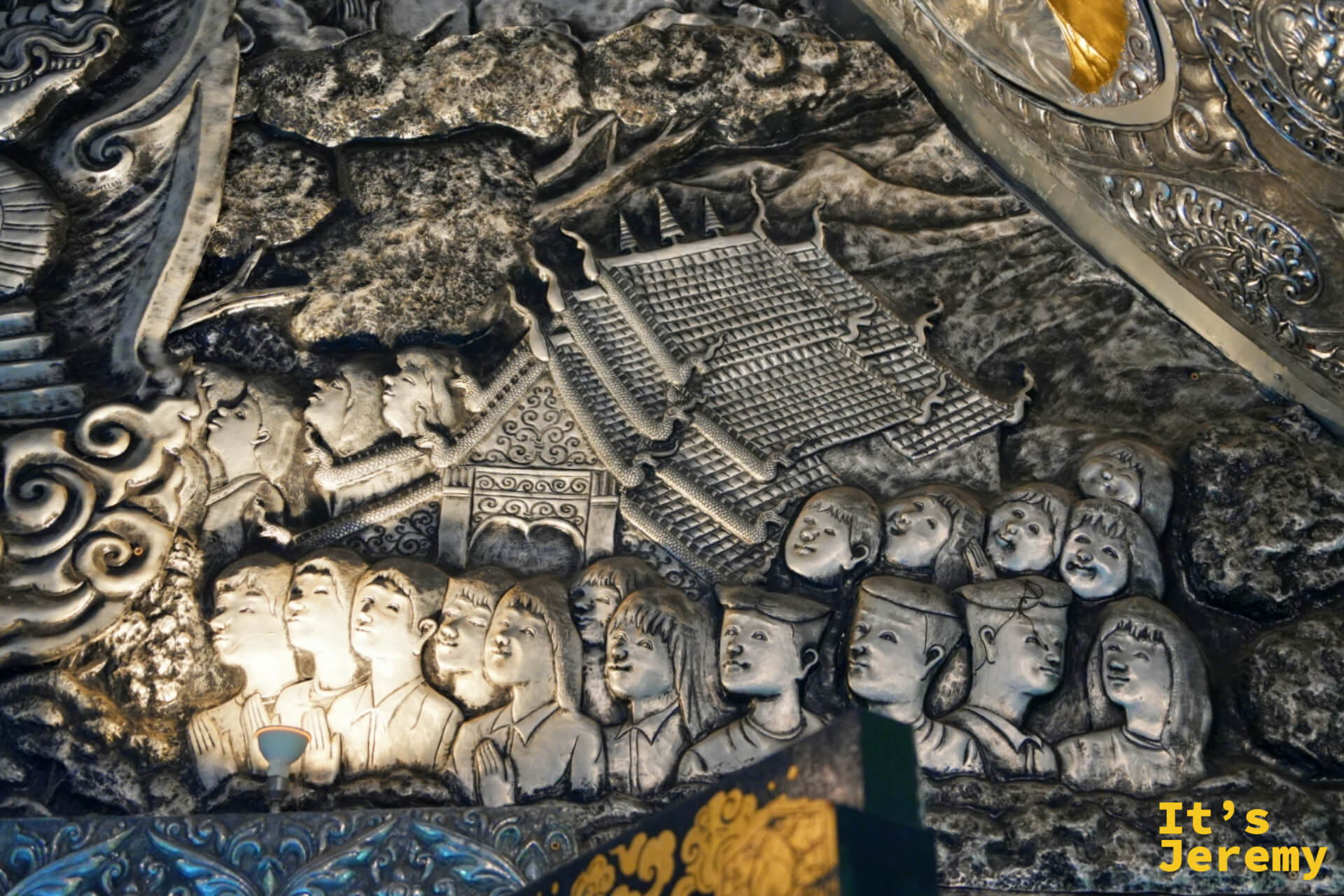 天花板浮雕，人物群像在寺廟前聚集，人物比例與構圖展現出高超的技藝