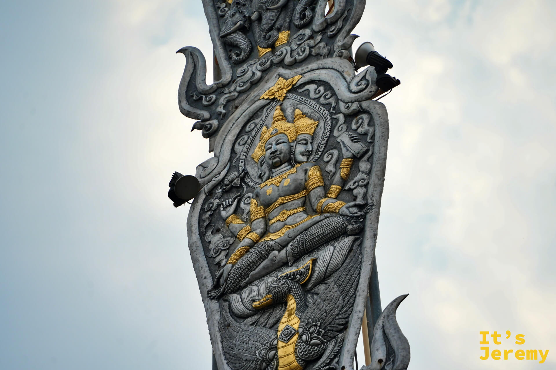 旗幡柱中段特寫，雙面神明浮雕面容細緻，金色裝飾搶眼