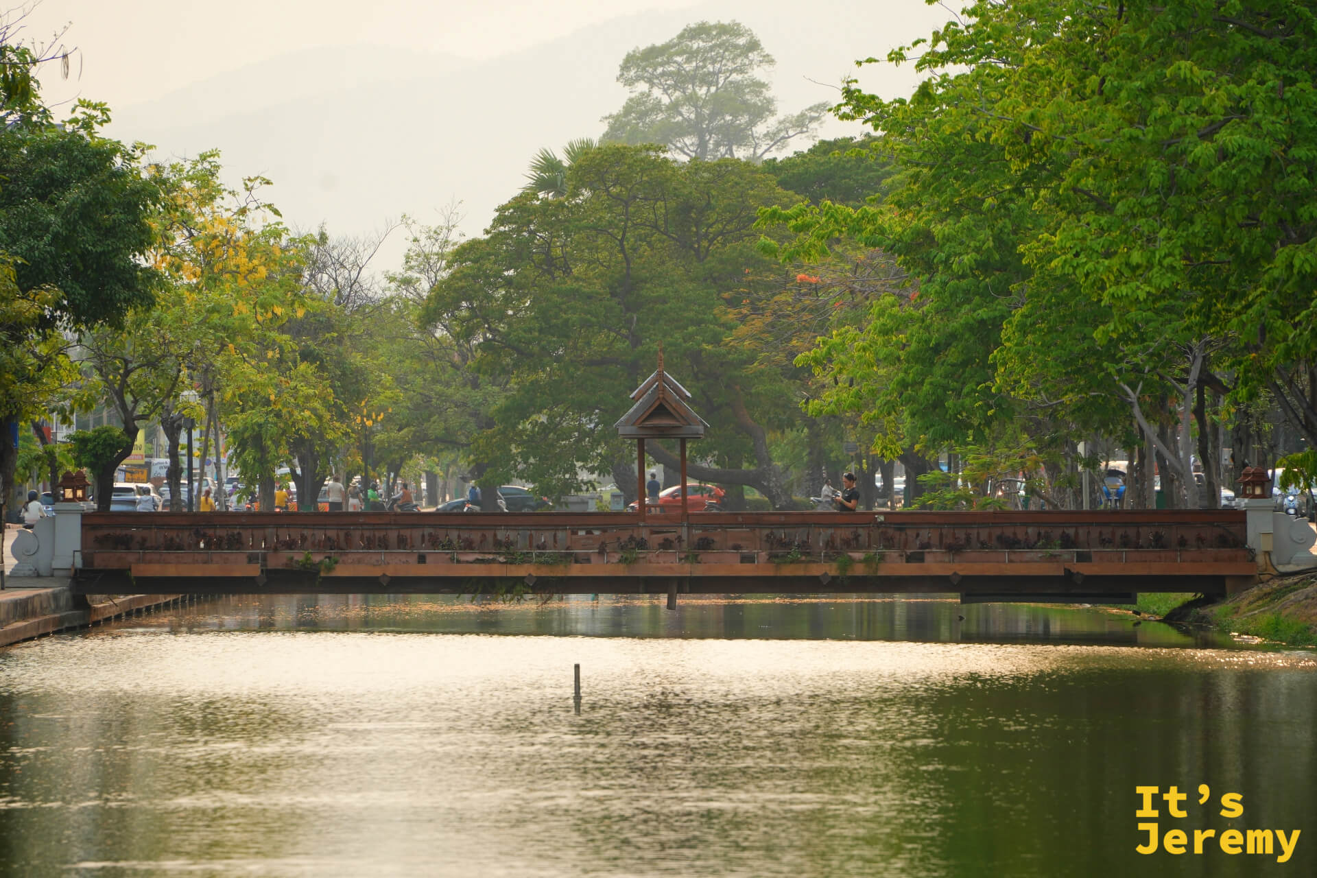 清邡護城河上的泰式涼亭拱橋,黃昏金光落在水面,橋身倒影清晰,兩岸樹木在夕照中暈染