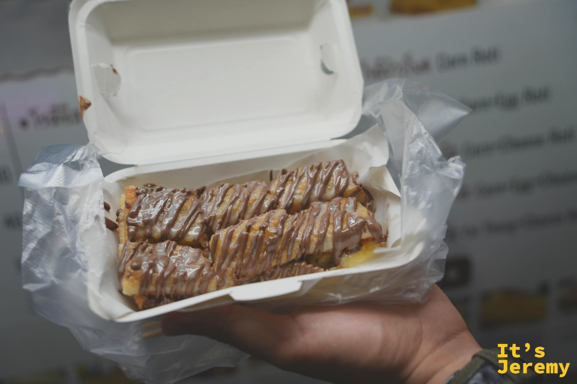 剛出爐的 Banana Nutella Roti，淋著榛果巧克力醬裝在外帶盒裡