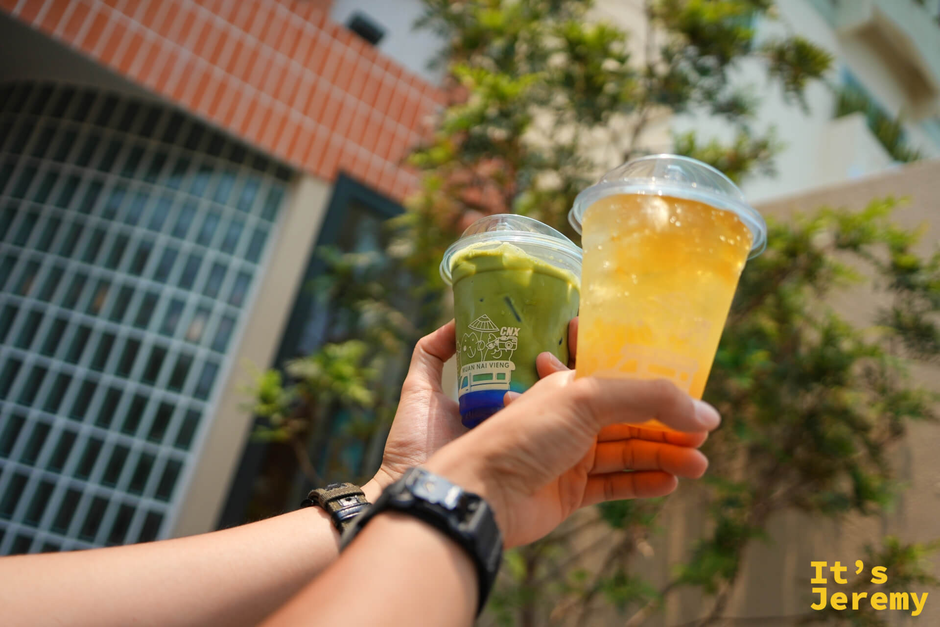 手持兩杯飲料：左邊抹茶歐蕾、右邊蜂蜜檸檬果凍氣泡飲