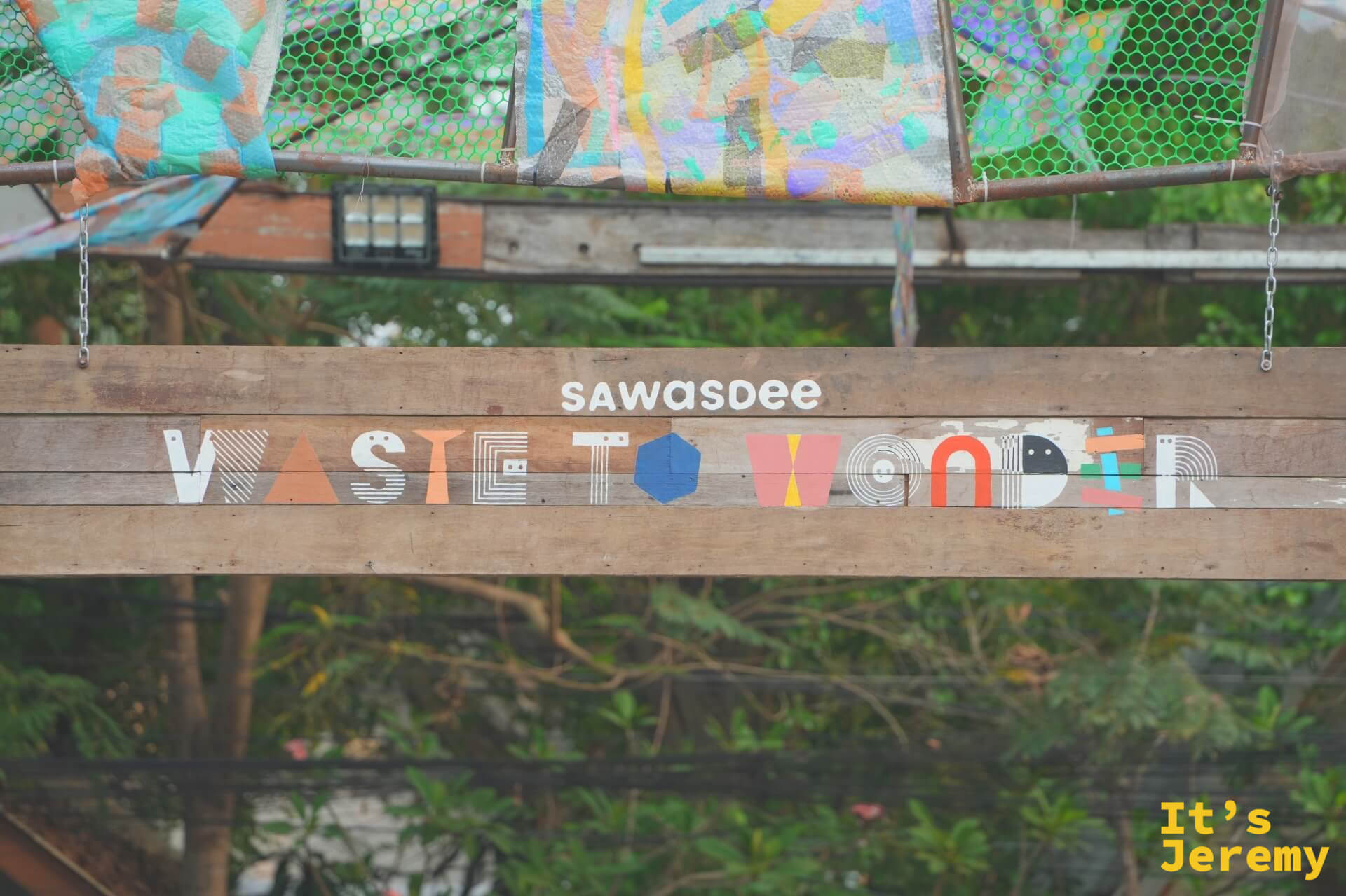 廊架主梁寫著「sawasdee WASTE TO WONDER」字樣,字母由彩色幾何圖形構成,充滿設計感