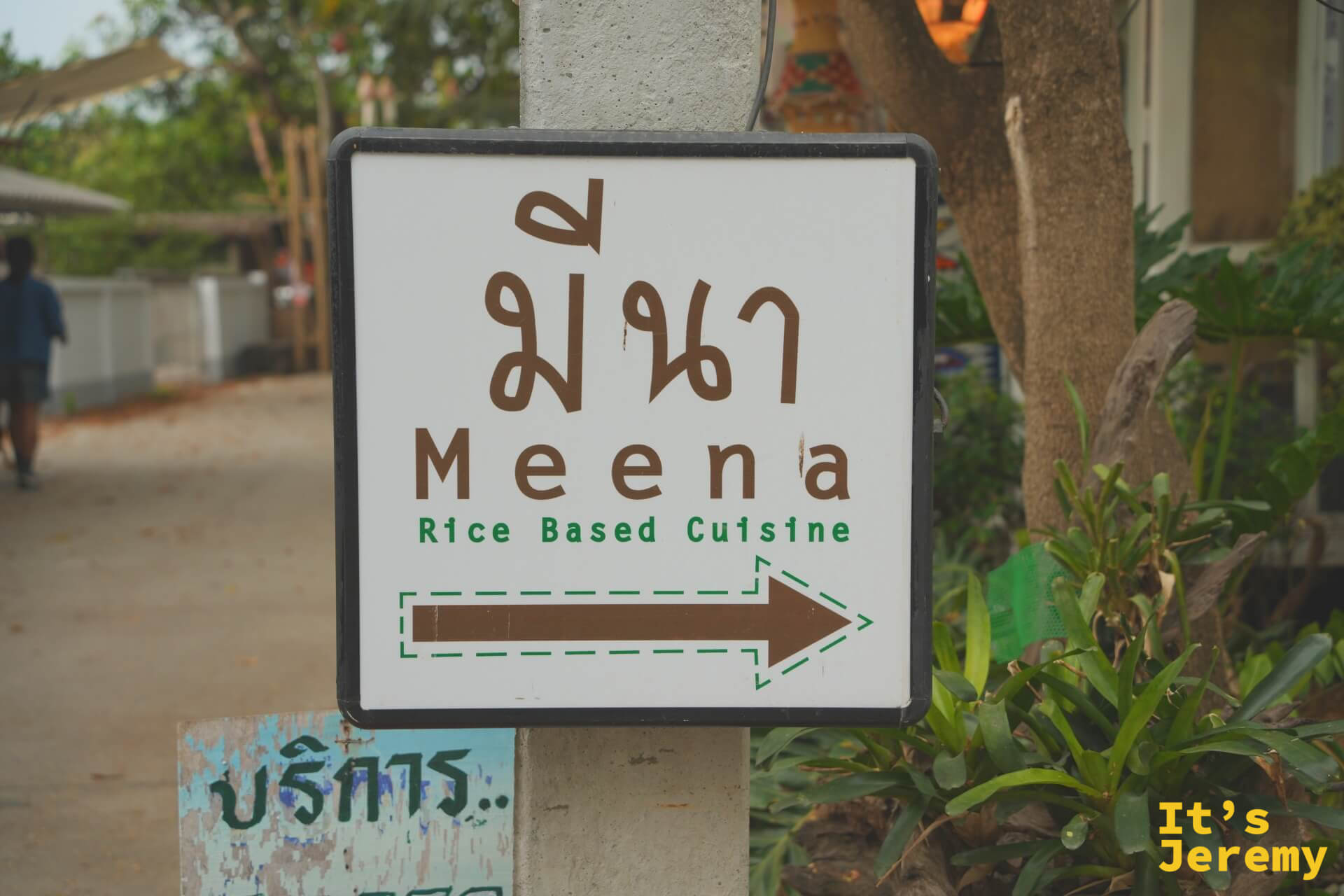 白色立牌上的 Meena 指路牌，泰文 มีนา 配英文與咖啡色箭頭