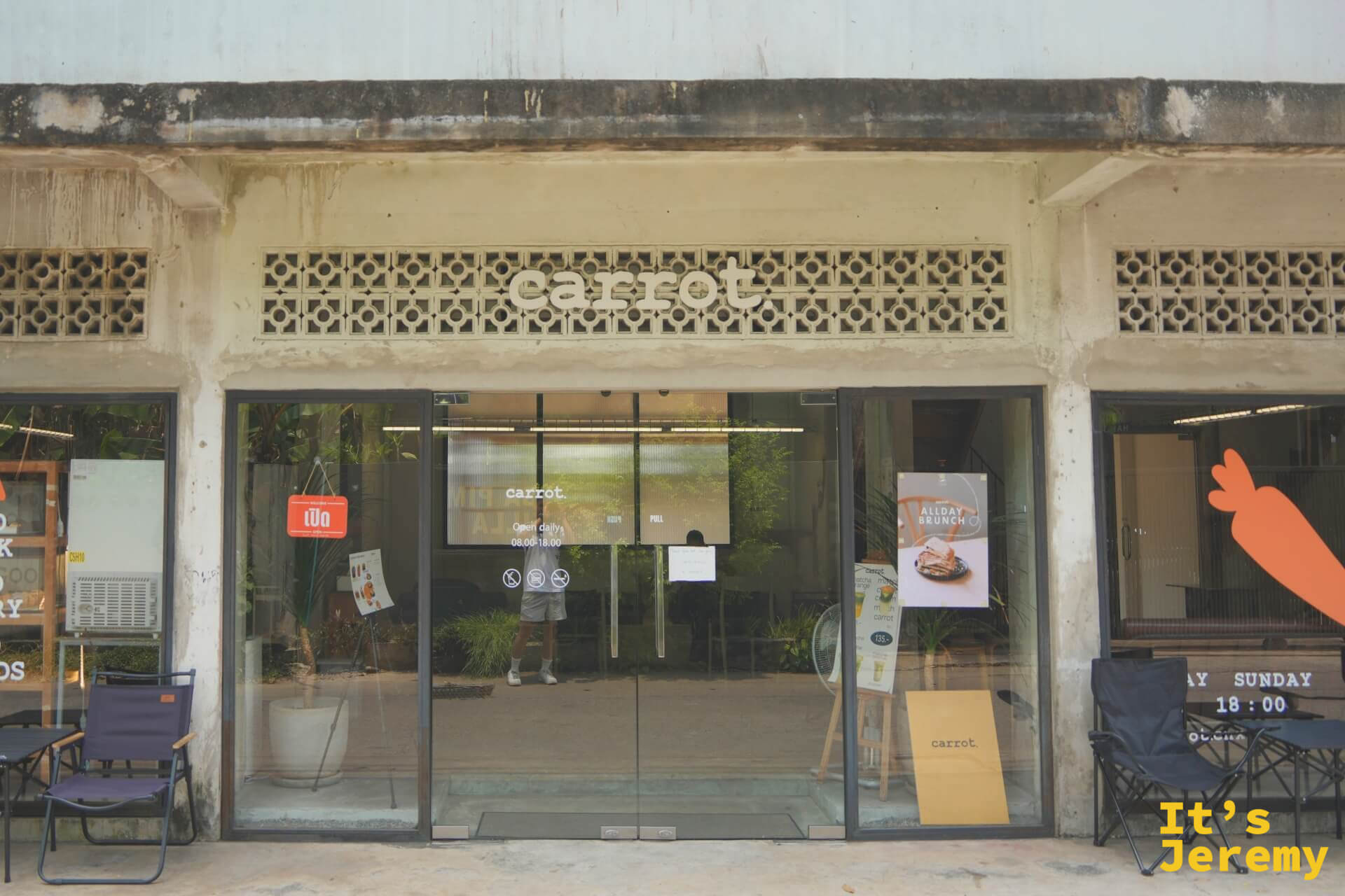 Carrot Coffee CNX 店面外觀，通風磚立面嵌著 carrot 字樣，玻璃門兩側擺著露營椅