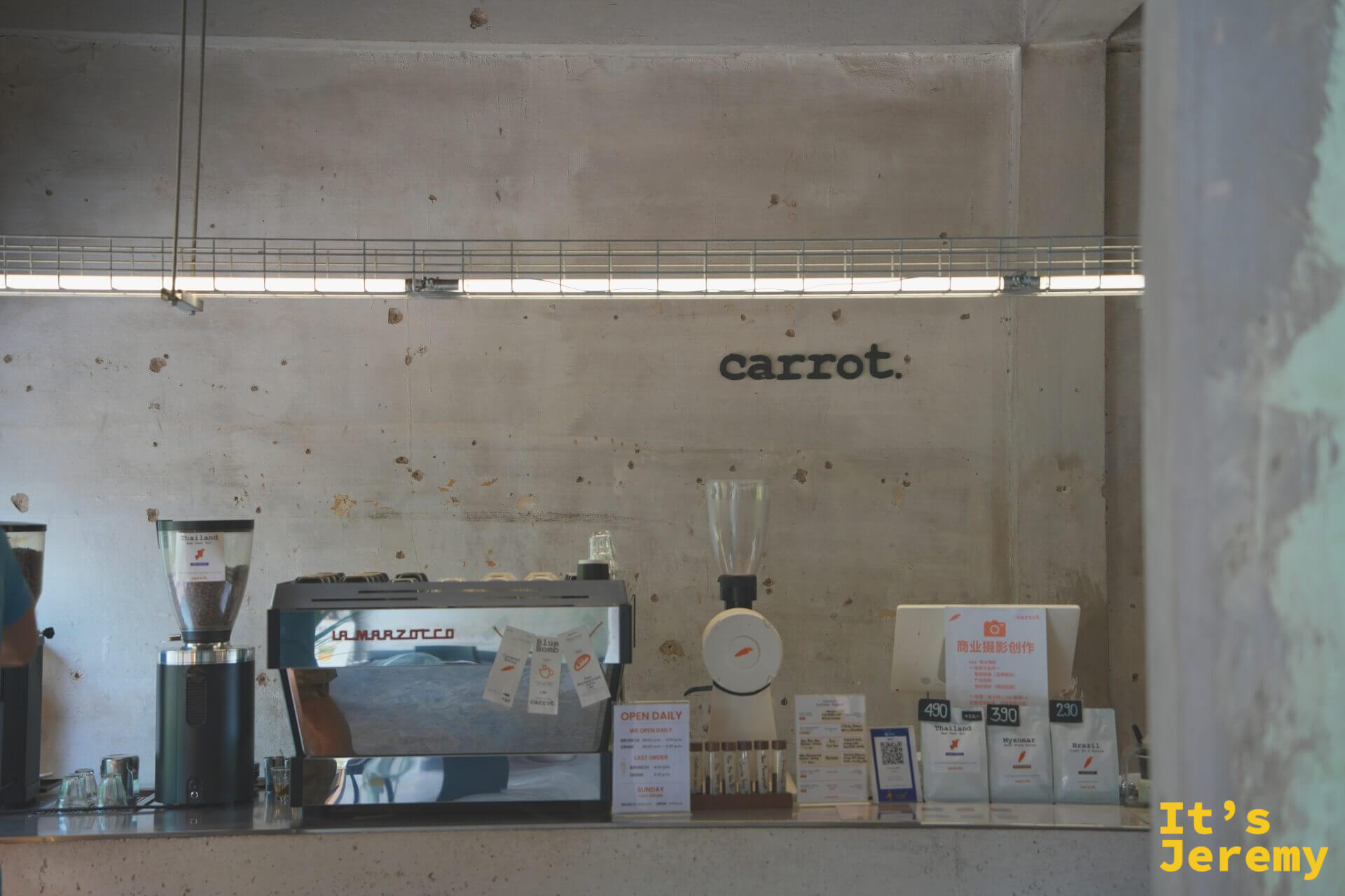 吧台全景，La Marzocco 義式機、胡蘿蔔磨豆機與牆上的 carrot. 字樣
