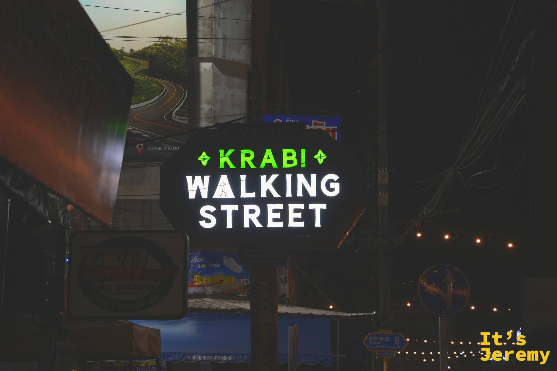 黑底八角形的 Krabi Walking Street 發光招牌掛在路口，綠白字體在夜色裡非常顯眼，下方還有 SINCE 2007 字樣