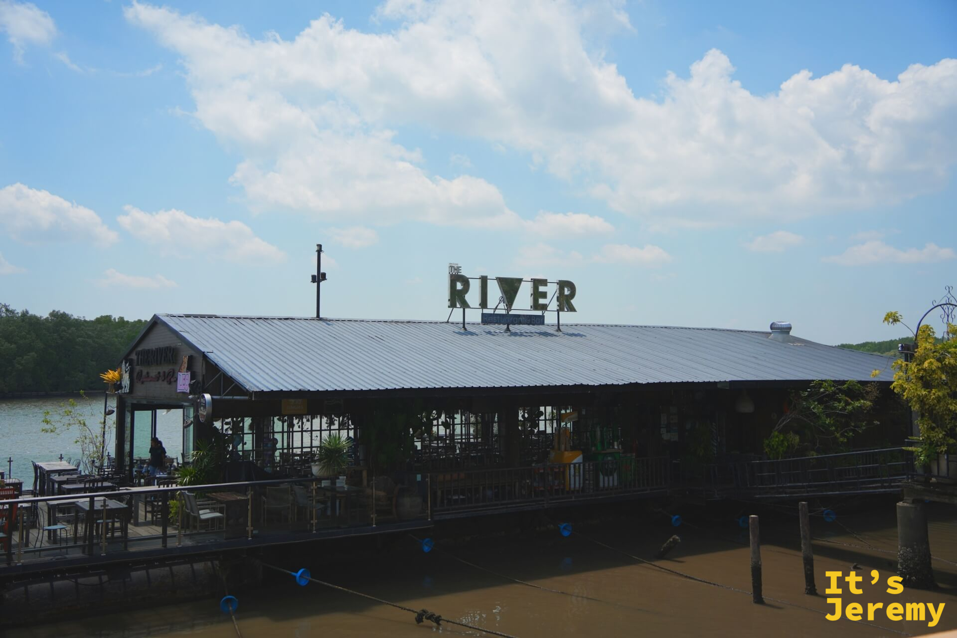 The River 餐廳外觀,屋頂大字招牌,背後是紅樹林