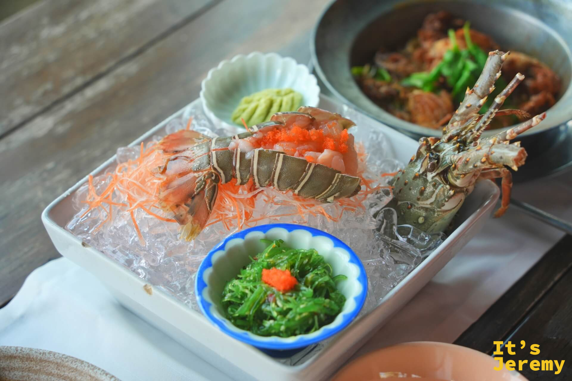 冰上擺放的龍蝦生魚片拼盤,附山葵和海草沙拉
