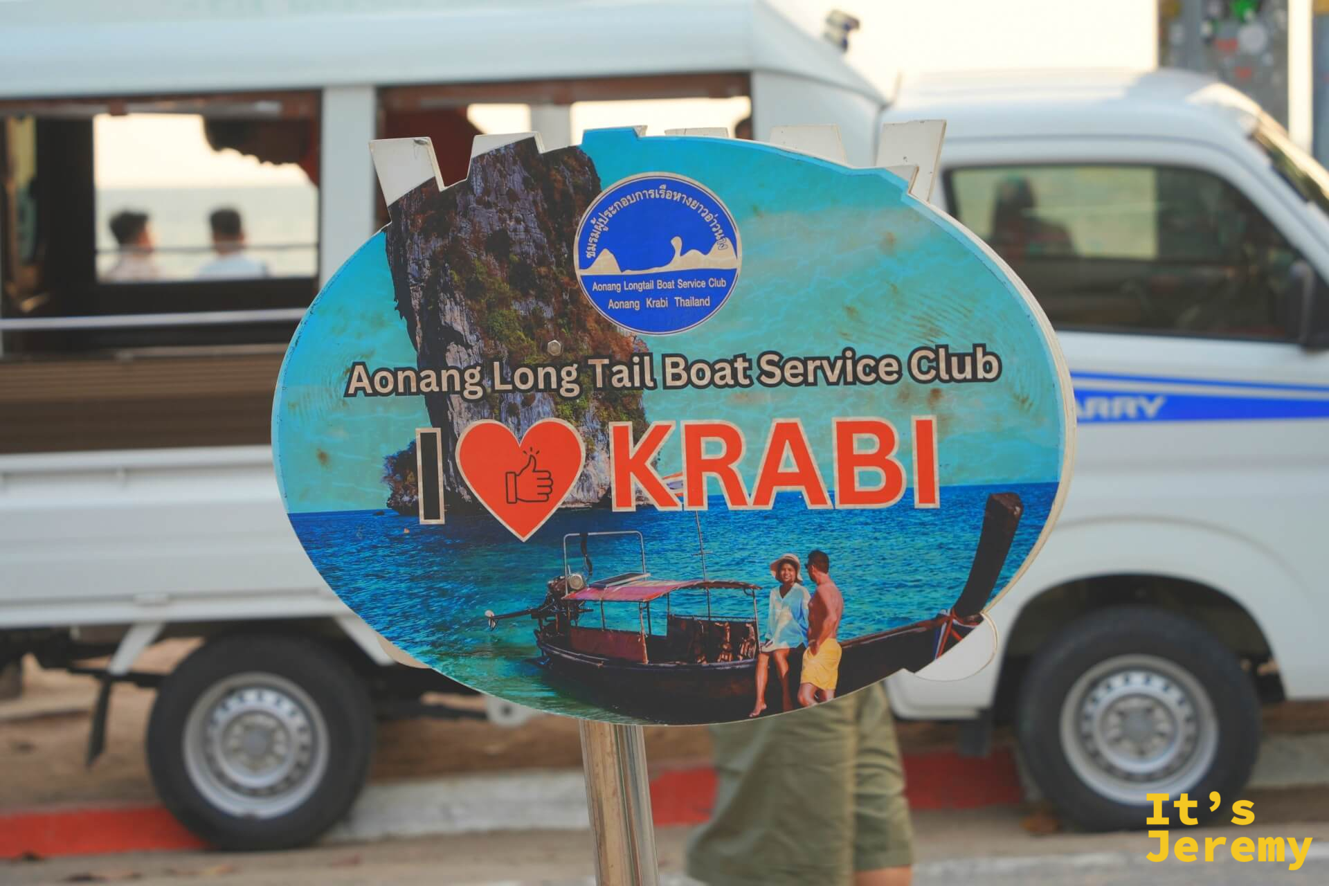Aonang Longtail Boat Service Club 看板，寫著「I ❤ KRABI」，背景是白色廂型車