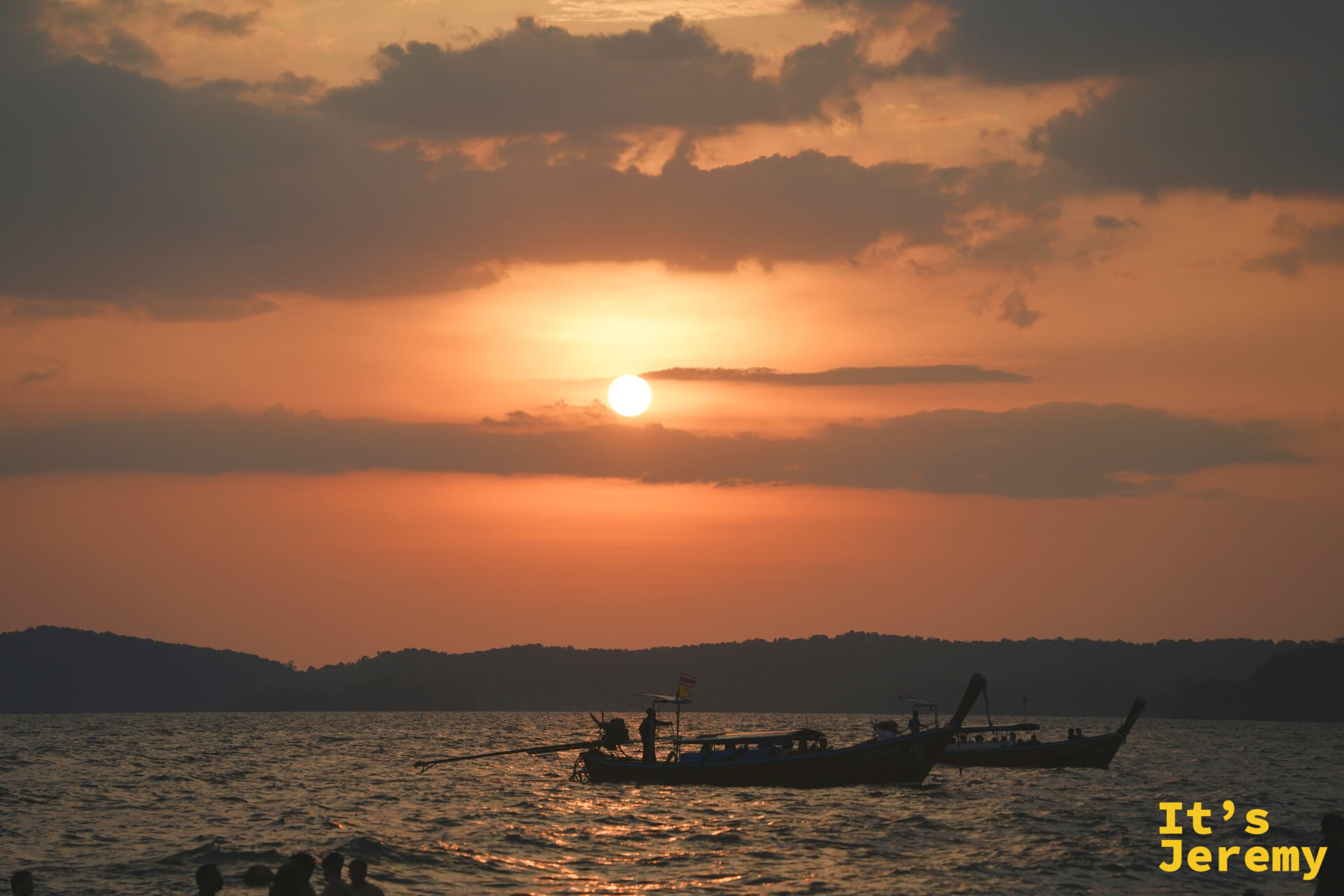 Ao Nang 全橘紅落日，太陽已接近地平線，兩艘小船遠影在寬闊海面上