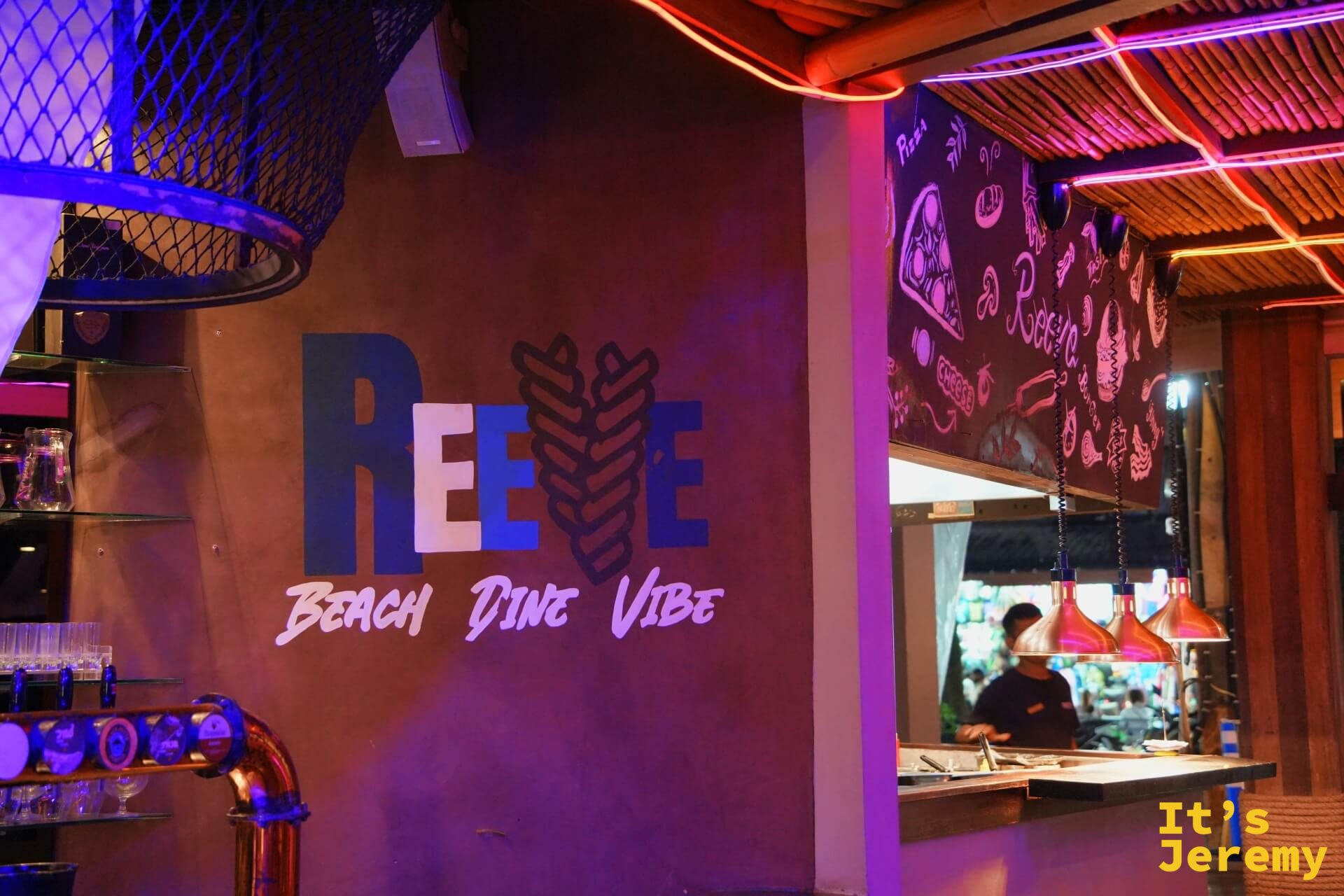 REEVE 室內牆面「Beach Dine Vibe」字樣,紫紅霓虹燈與開放式廚房