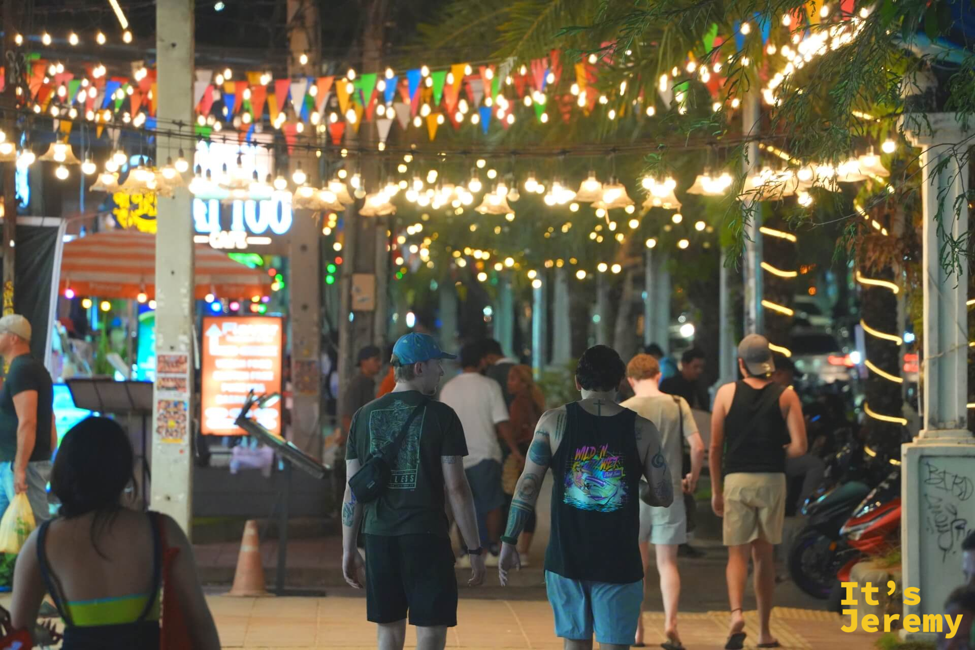 Night Market Place Krabi 入口夜景，彩旗燈串在人群頭頂延伸