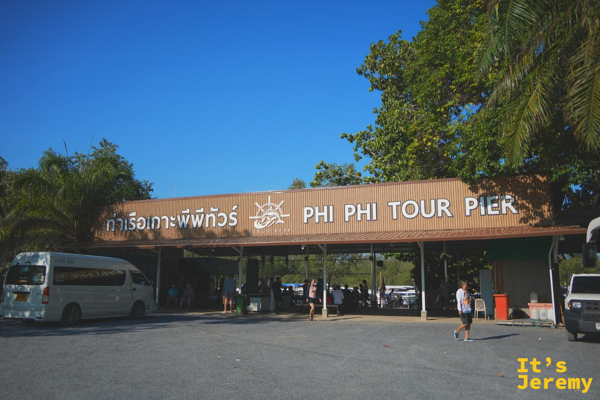 Phi Phi Tour Pier 外觀，停車場有小巴停靠，棚架下是報到與候船區域