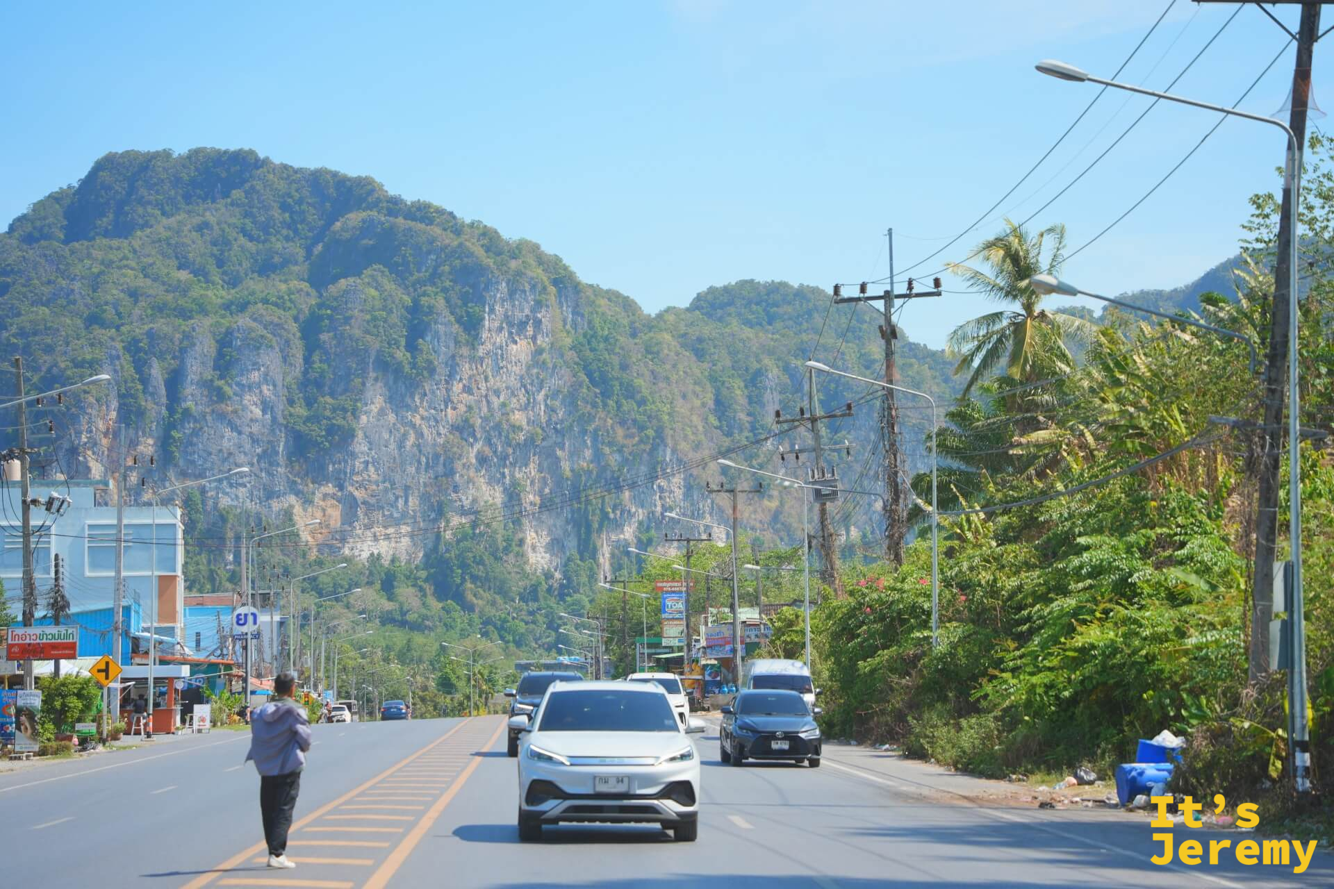 從雙條車後車廂往外看，公路延伸向前，遠方是喀比的石灰岩山脈輪廓