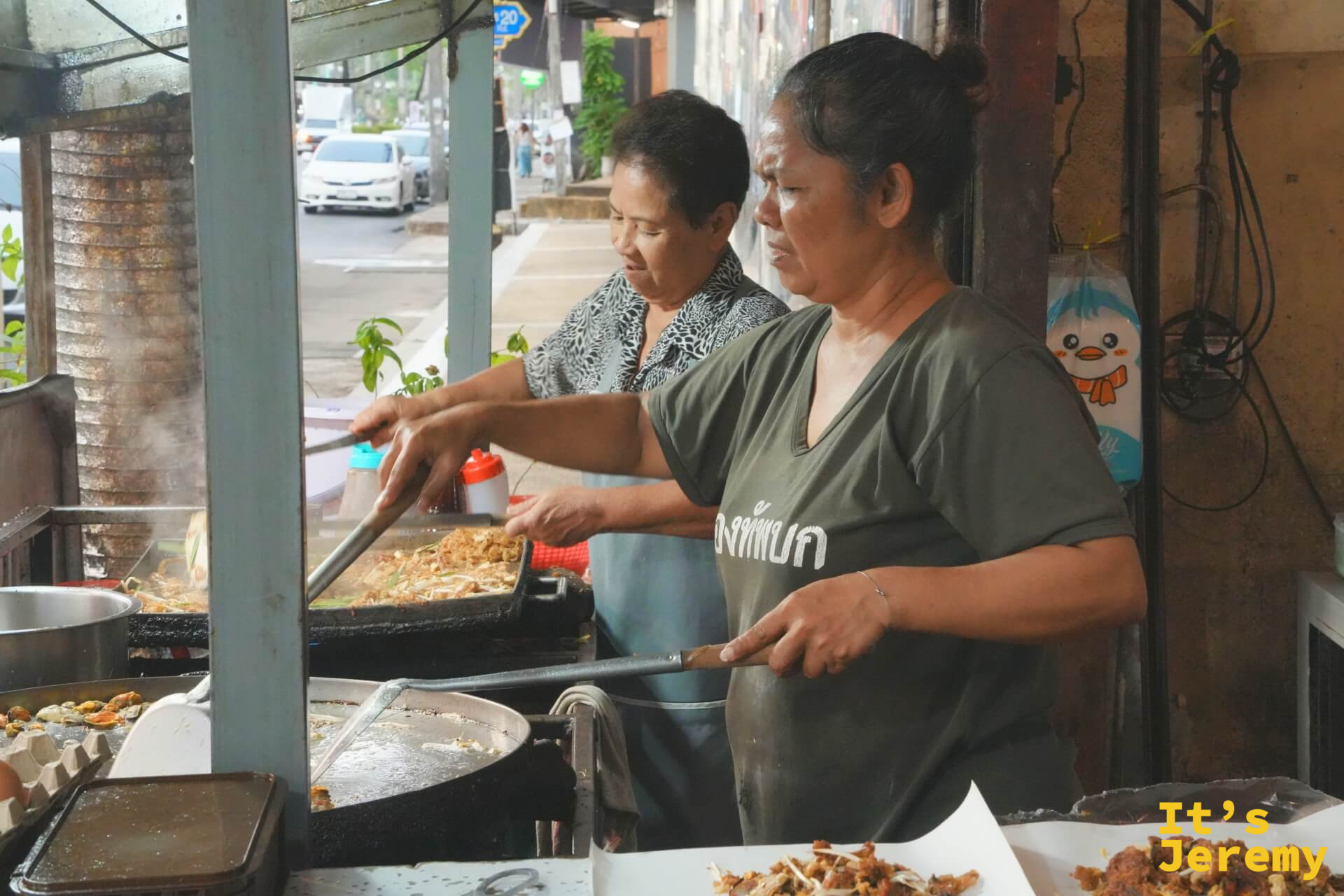 ผัดไทย 50 บาท 攤位的兩位大姐，分守兩口鐵鍋，專注備料炒菜
