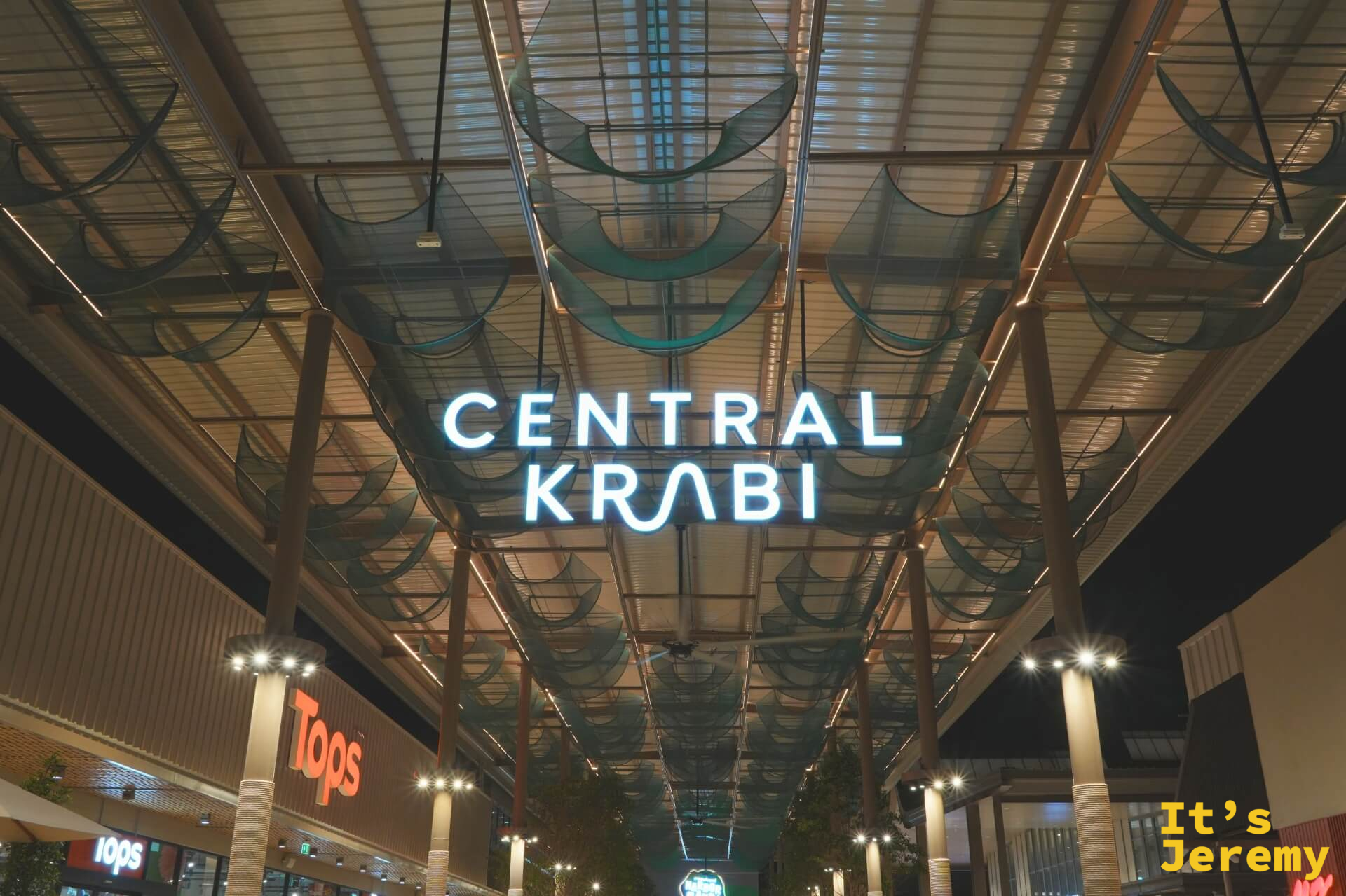Central Krabi 室內入口走廊夜景,頂部有半圓形弧狀裝飾,兩側可見 Tops 招牌