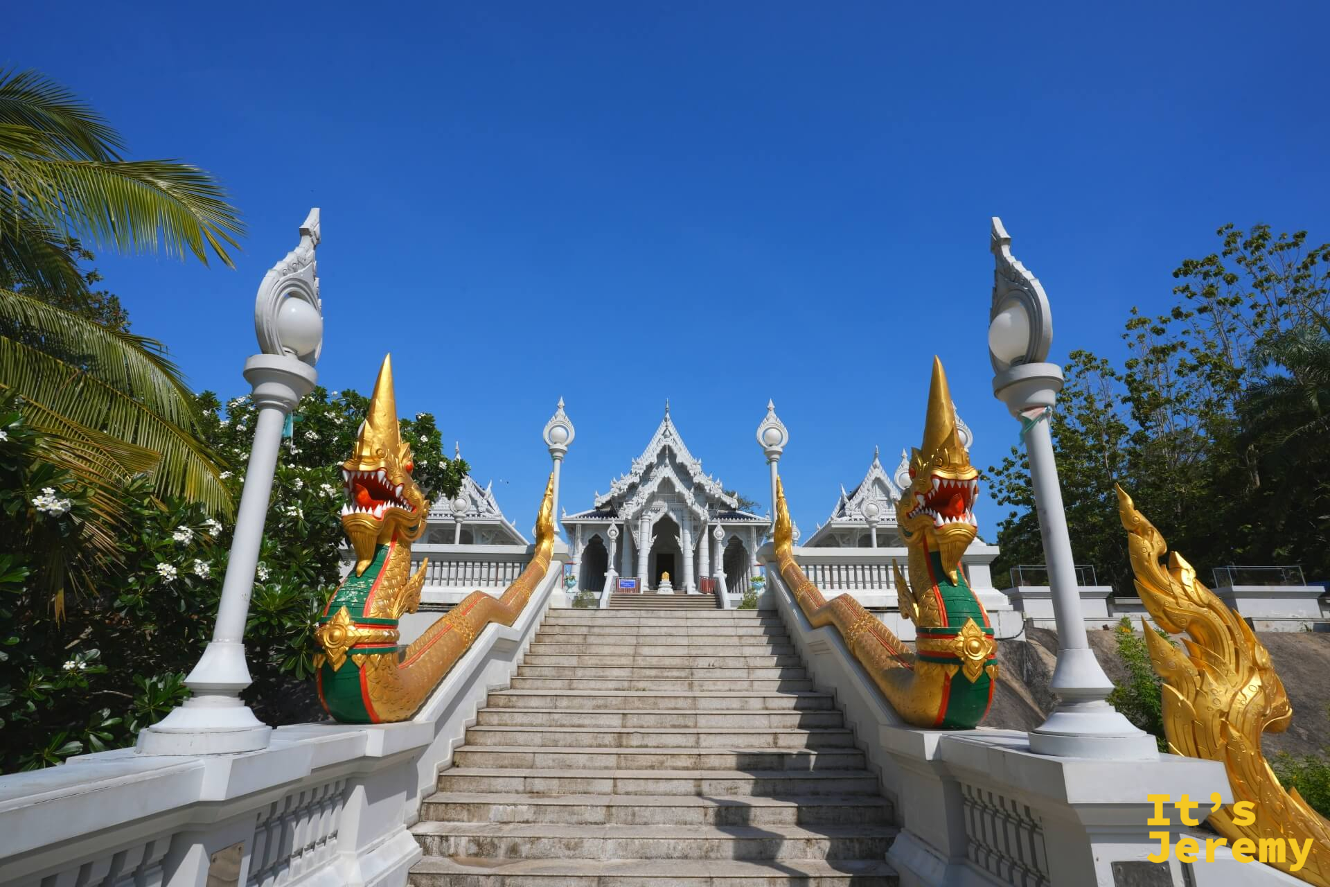 通往主殿的石階兩側,金色那迦雕像口大開,護衛著白色大殿入口
