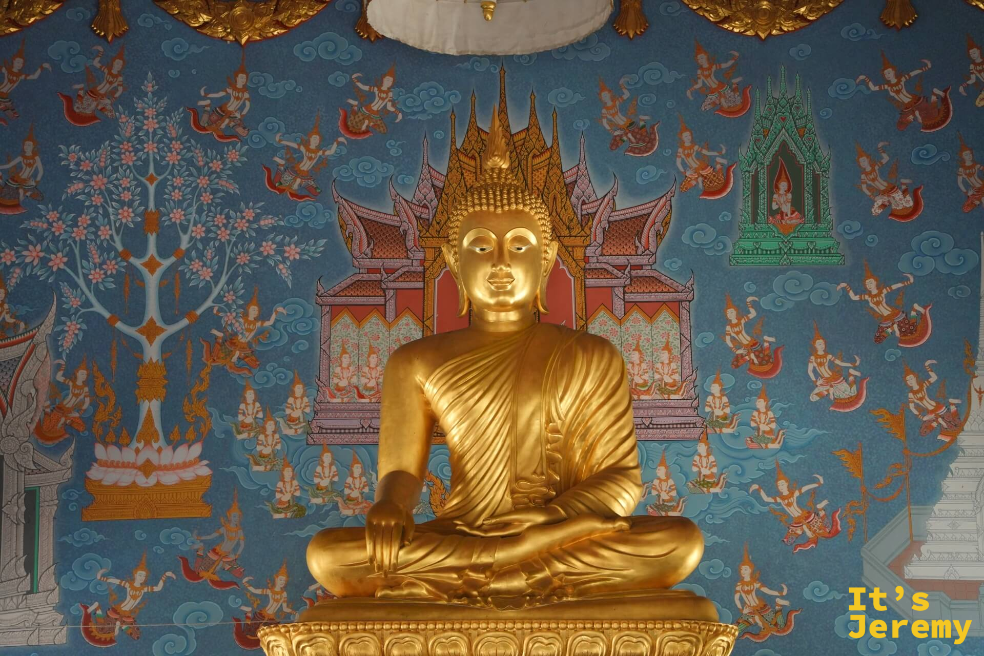 主殿內部金色坐佛,藍色天界壁畫為背景,佛像以觸地印姿態端坐正中
