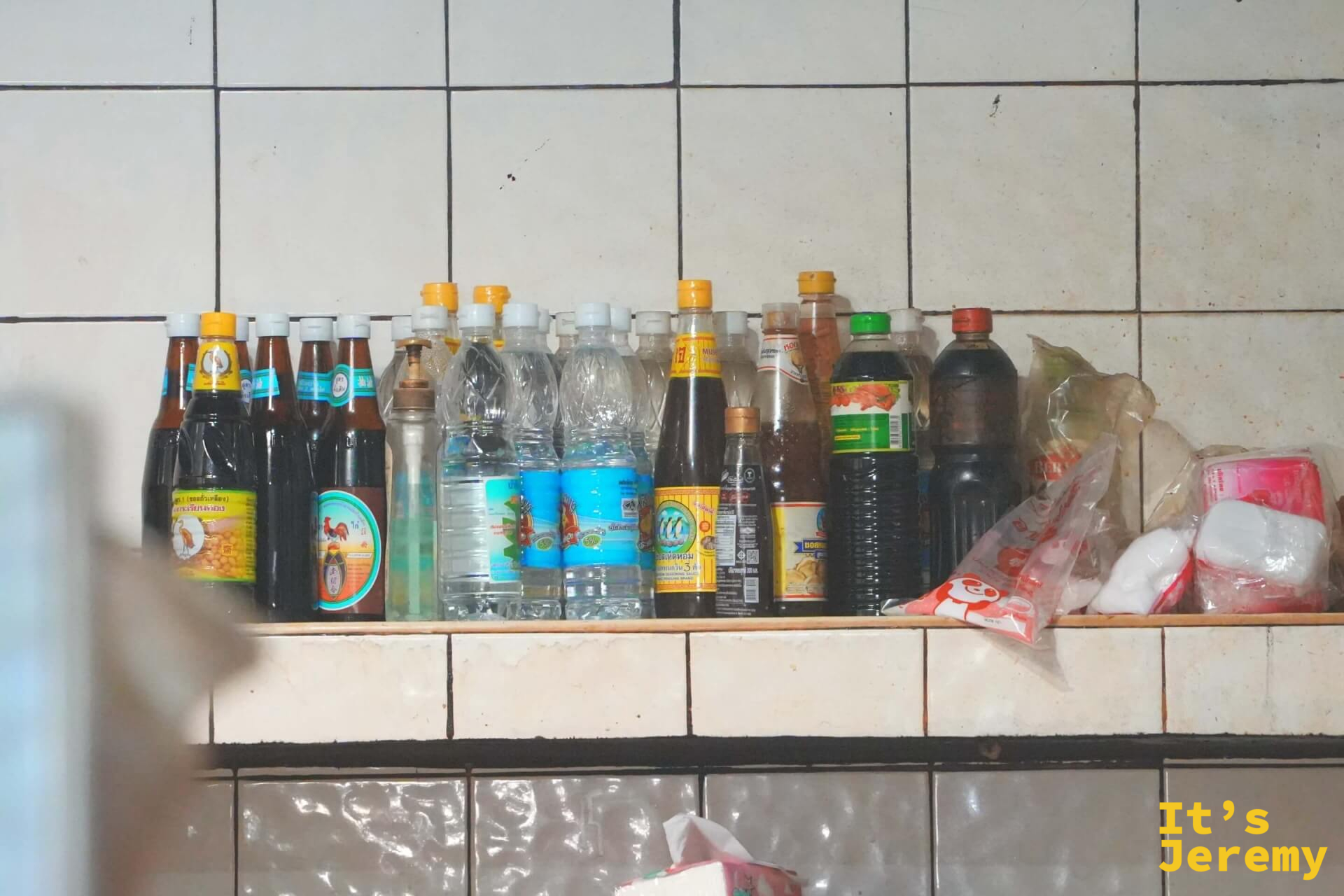 廚房牆面一整排各式調味醬料瓶,是店內調醬配方的日常風景