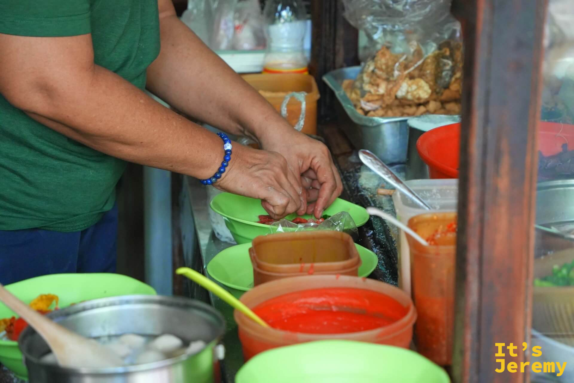 師傅手工組碗:將食材逐一擺入綠色碗中,旁邊備有各色醬汁桶與配料