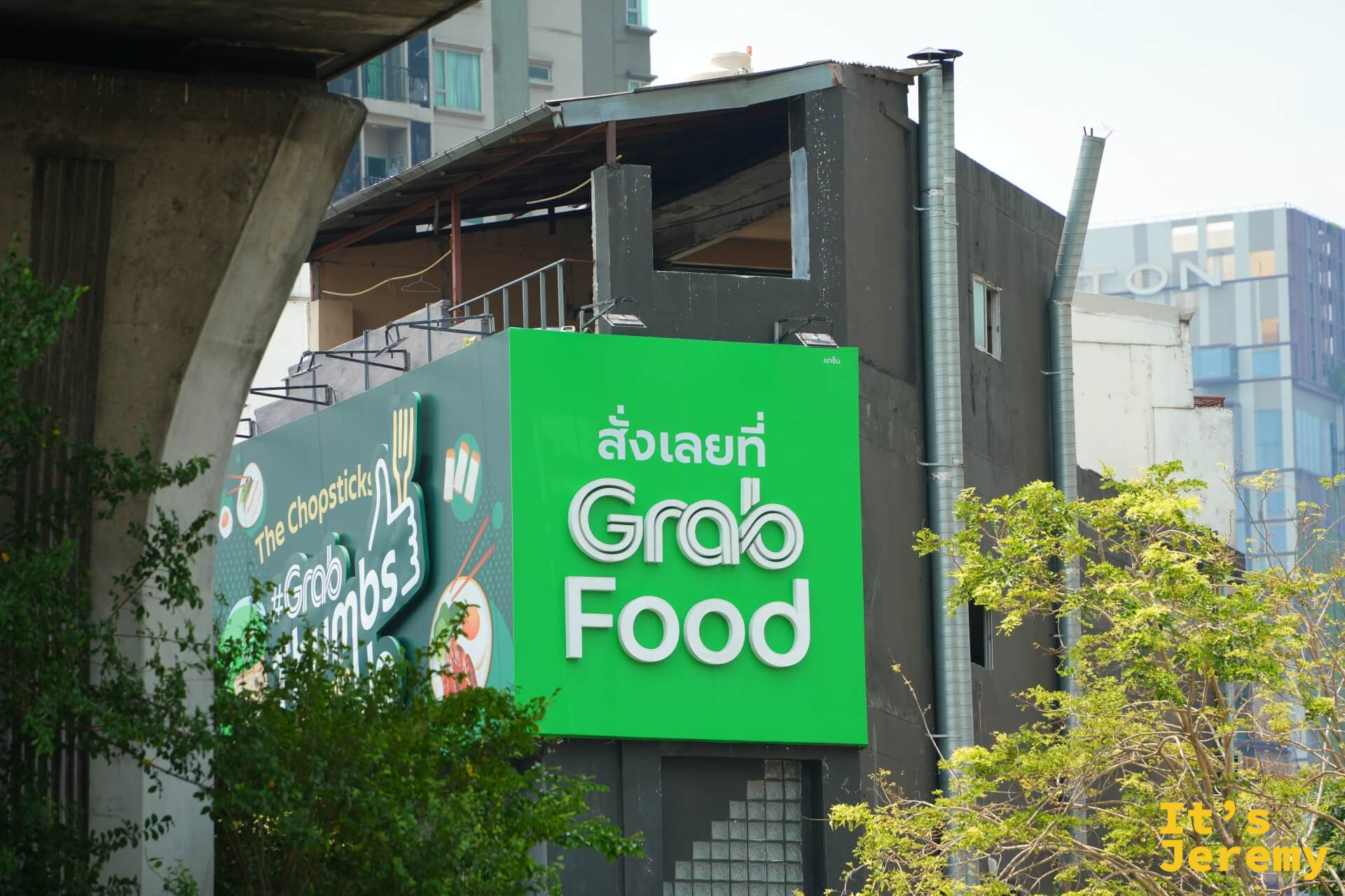 路旁的 GrabFood 廣告看板,綠色品牌色佔滿整個版面,在曼谷任何角落幾乎都能看到 Grab 的影子