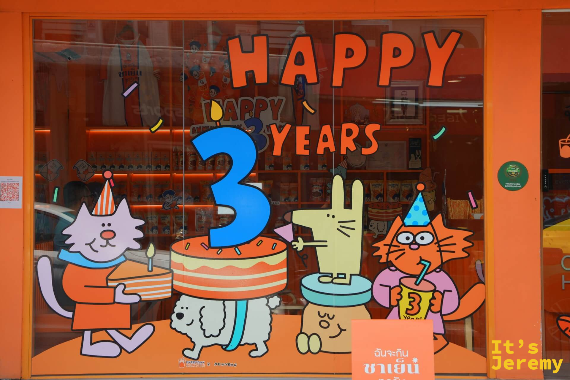 店窗玻璃貼著 Happy 3 Years 慶生插圖,貓、兔、小狗圍著生日蛋糕,充滿品牌插畫風格