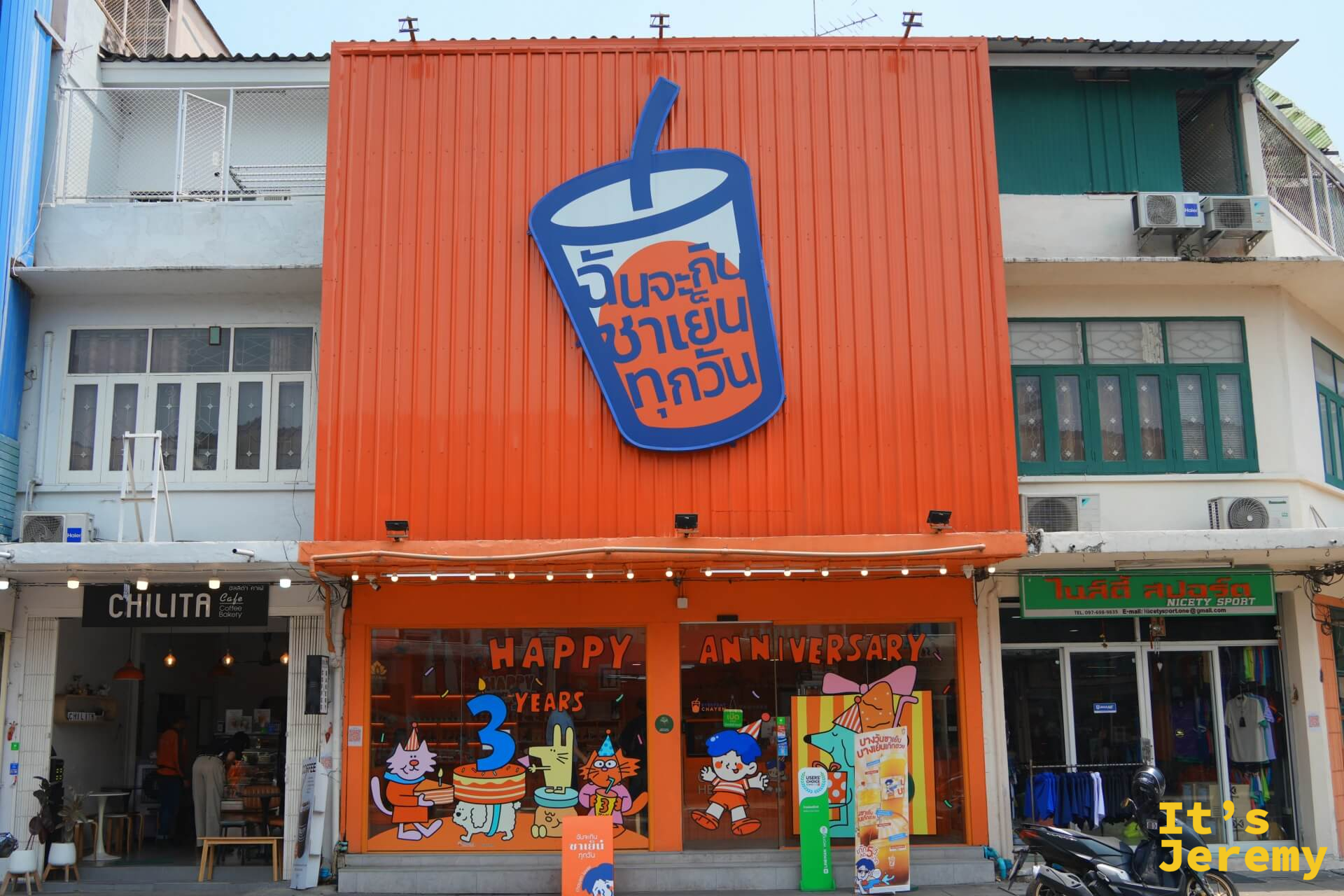 Everyday Thai Tea 店外全景,橘色兩層樓建築,店門貼滿 Happy 3 Years Anniversary 的貓兔慶生插圖