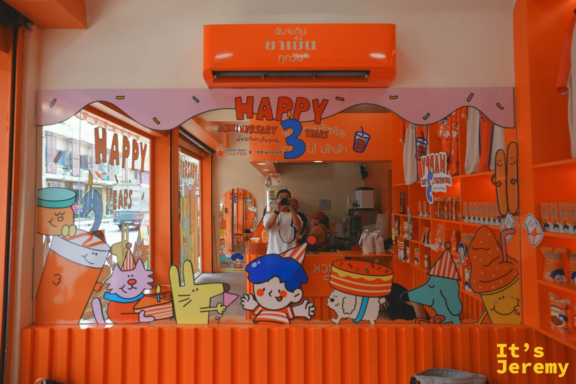 透過鏡面看到店內全景反射,Jeremy 舉起相機拍攝,兩側貼有「Happy Anniversary 3 Years」文字