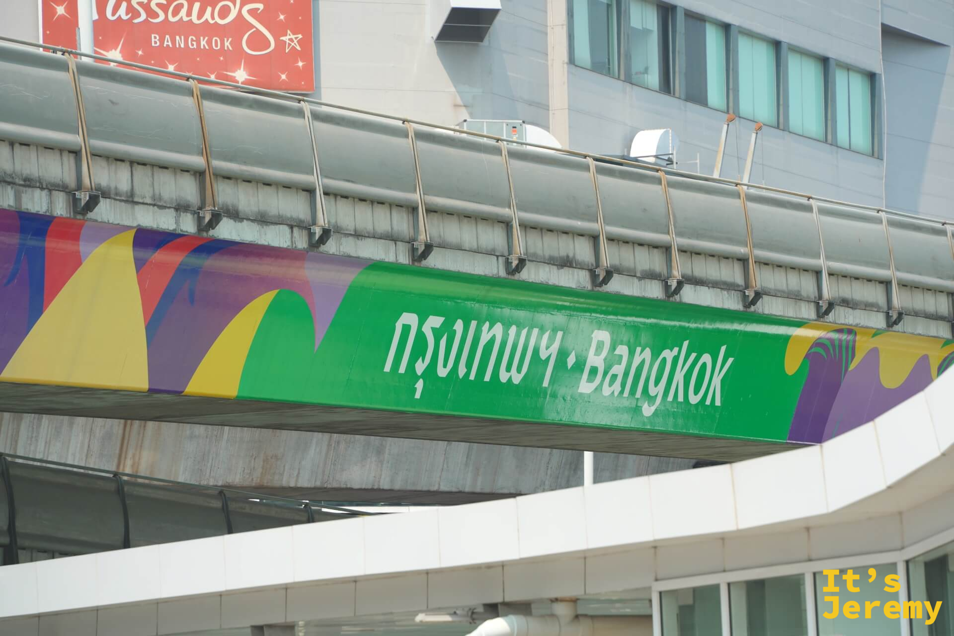 BTS 天橋上的方向指示牌,上頭印著「กรุงเทพ・Bangkok」金色字體,藍天做背景,字跡清晰