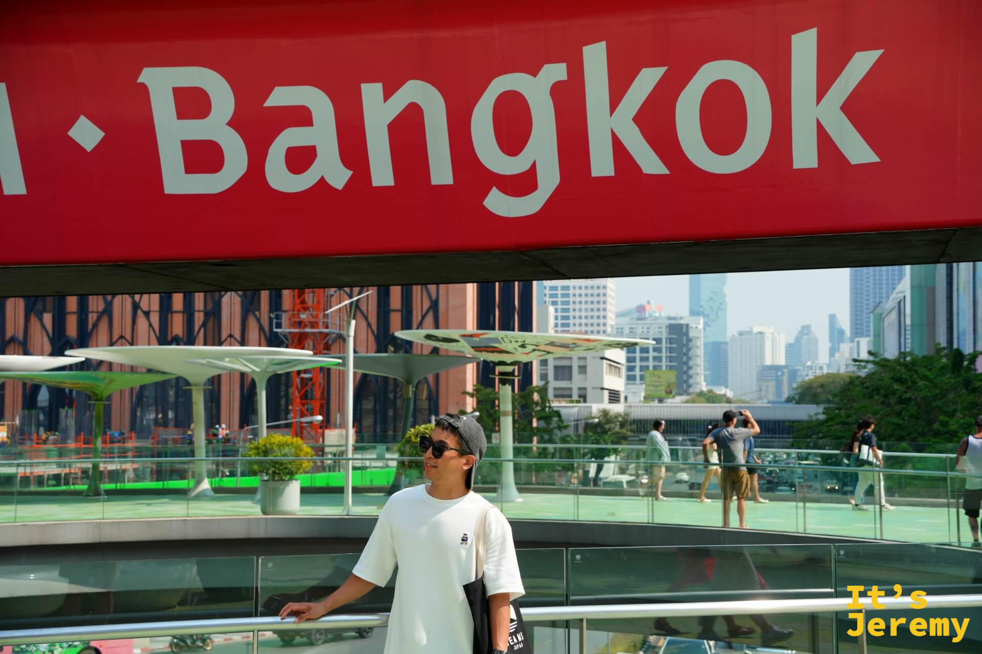 Jeremy 站在 Central World 一帶的大型紅底「Bangkok」字樣招牌前,笑著拍照,這個招牌是暹羅商圈的地標打卡點之一