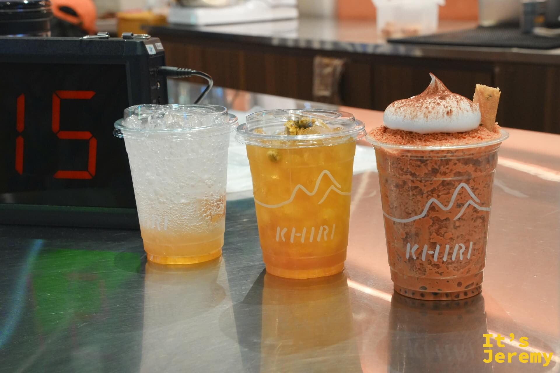 三杯飲料並列在取餐台:左邊 Yuzu Plum Fizz、中間 Wild Honey 琥珀色、右邊是頂著奶蓋和椰子捲的 On Cloud