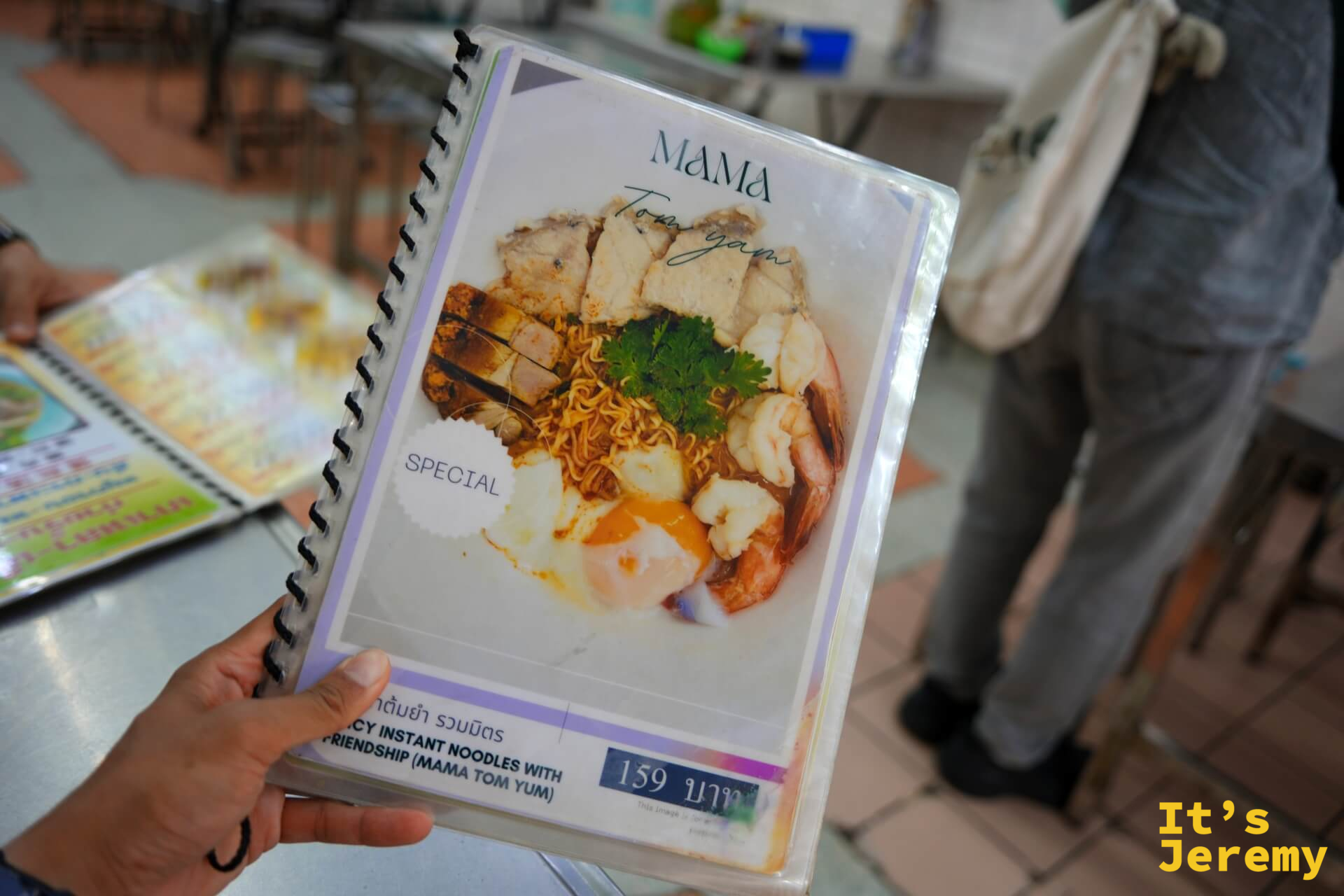 手持菜單本,封面是 MAMA Tom Yam 特餐照片,標示 SPECIAL,定價 159 泰銖