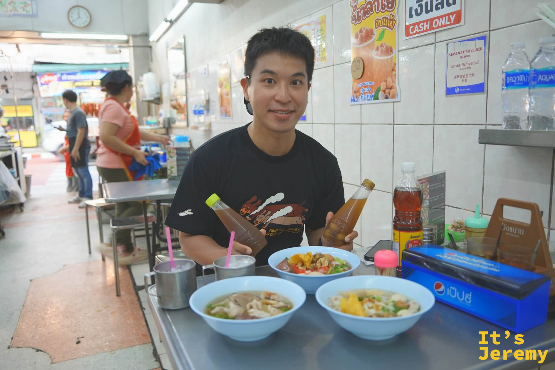 Jeremy 坐在桌前笑著,面前擺著三碗不同口味的湯,背景牆上貼著「CASH ONLY」標示