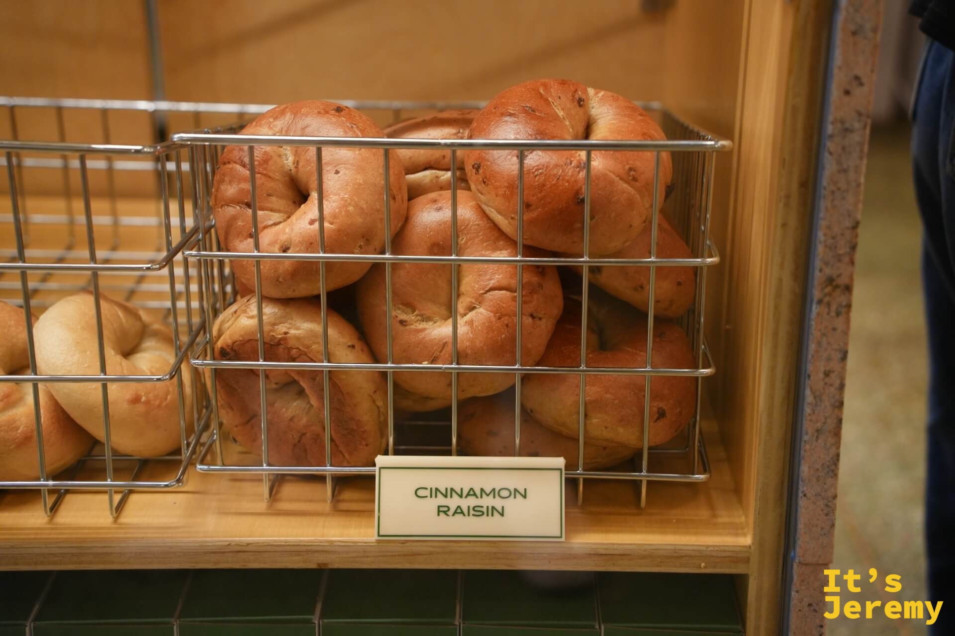 Cinnamon Raisin 貝果堆疊在籃中，深棕色烤色，散發烤香