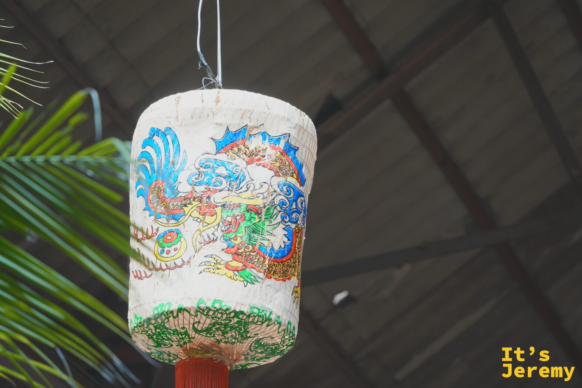 龍紋彩繪紙燈籠懸吊在舊木構屋架下